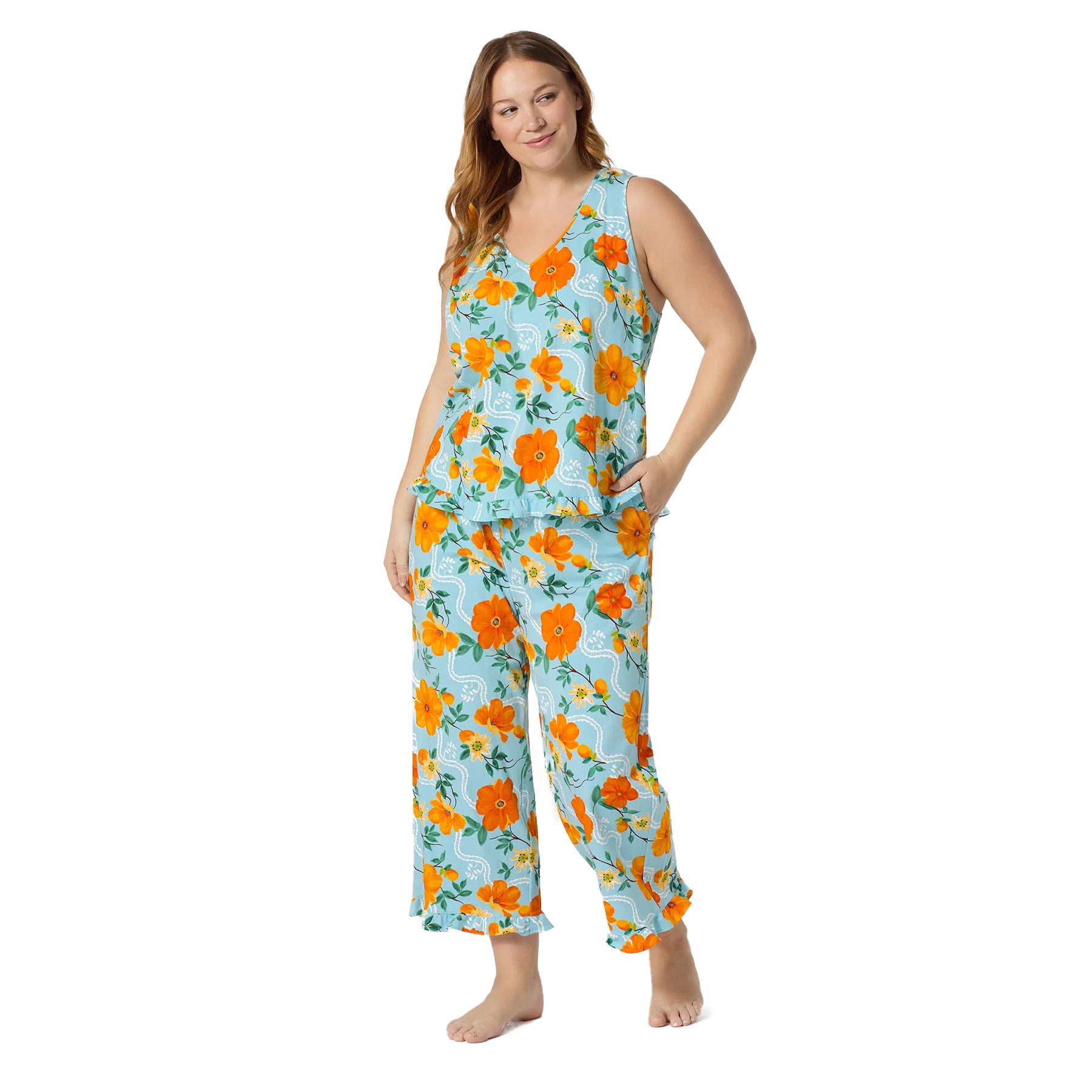 Plus size model wearing a soft aqua blue floral lounge set with orange blossom print, sleeveless top, and comfortable cropped pants.