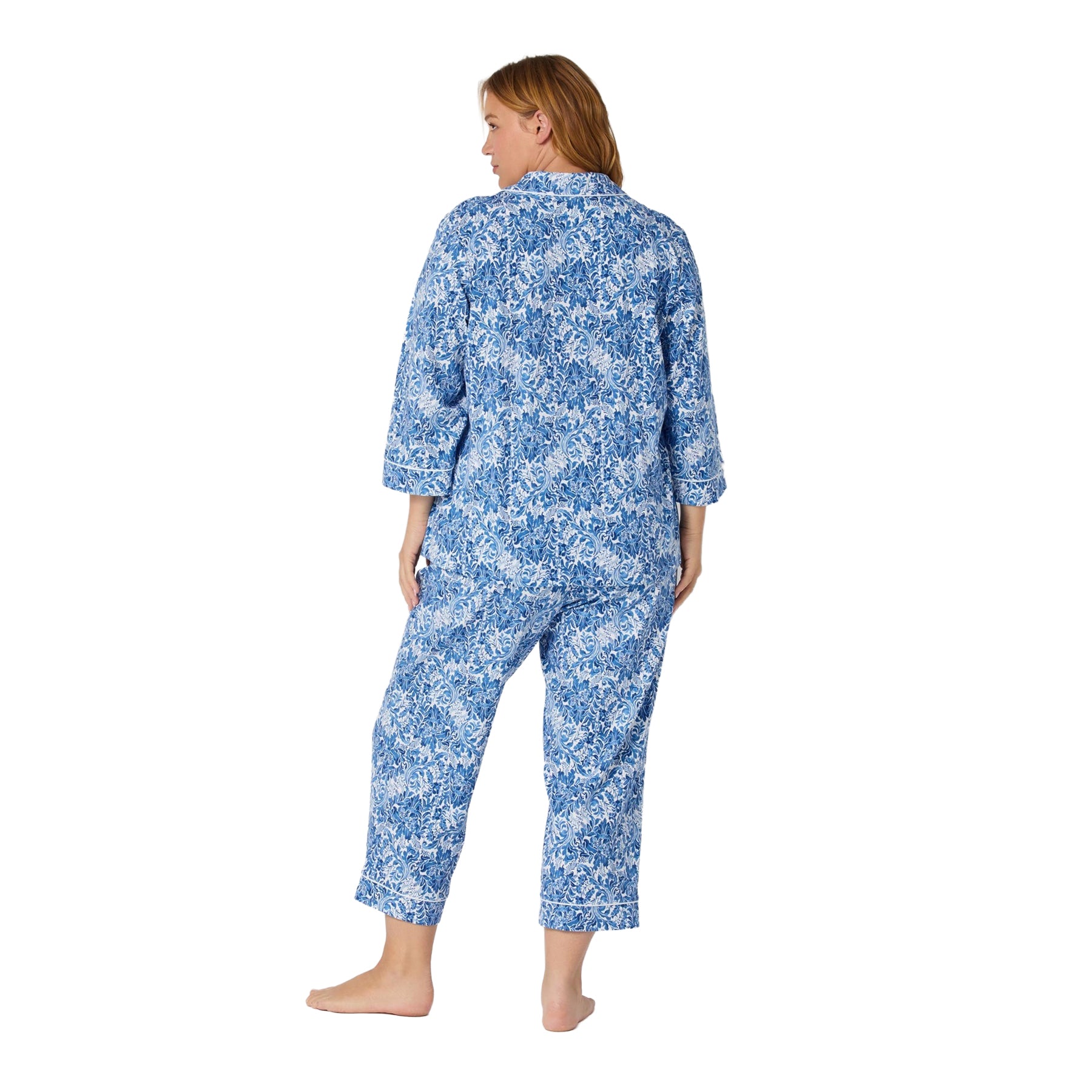 Woman wearing a blue floral pajama set on a white background