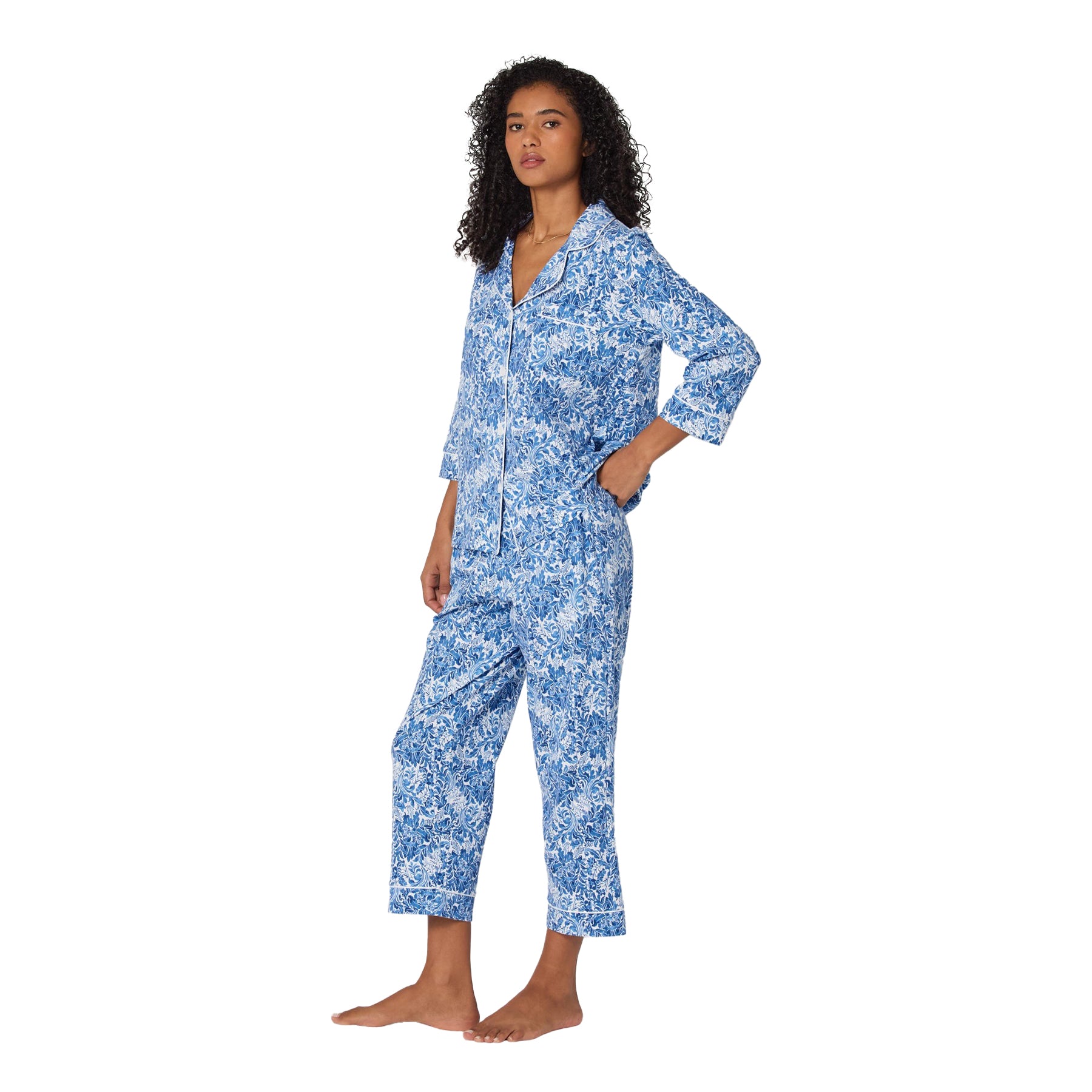 Woman wearing a blue floral pajama set on a white background