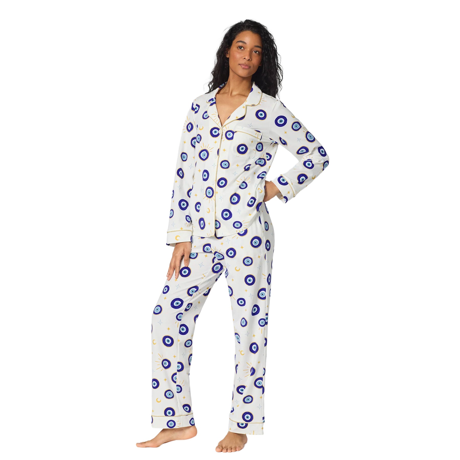Woman modeling BedHead classic white button-front pajamas with blue evil eye, moon and star print.