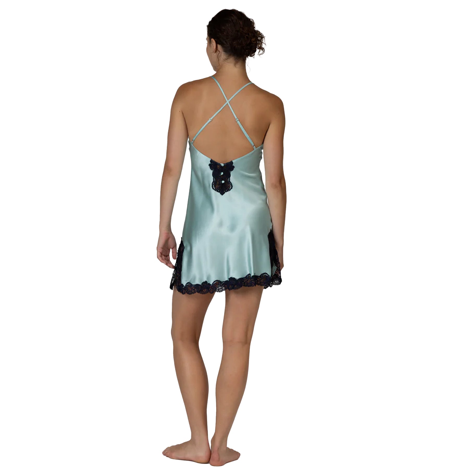 Back view of aquamarine satin chemise featuring crossed straps, navy lace detailing, and a soft silky finish.