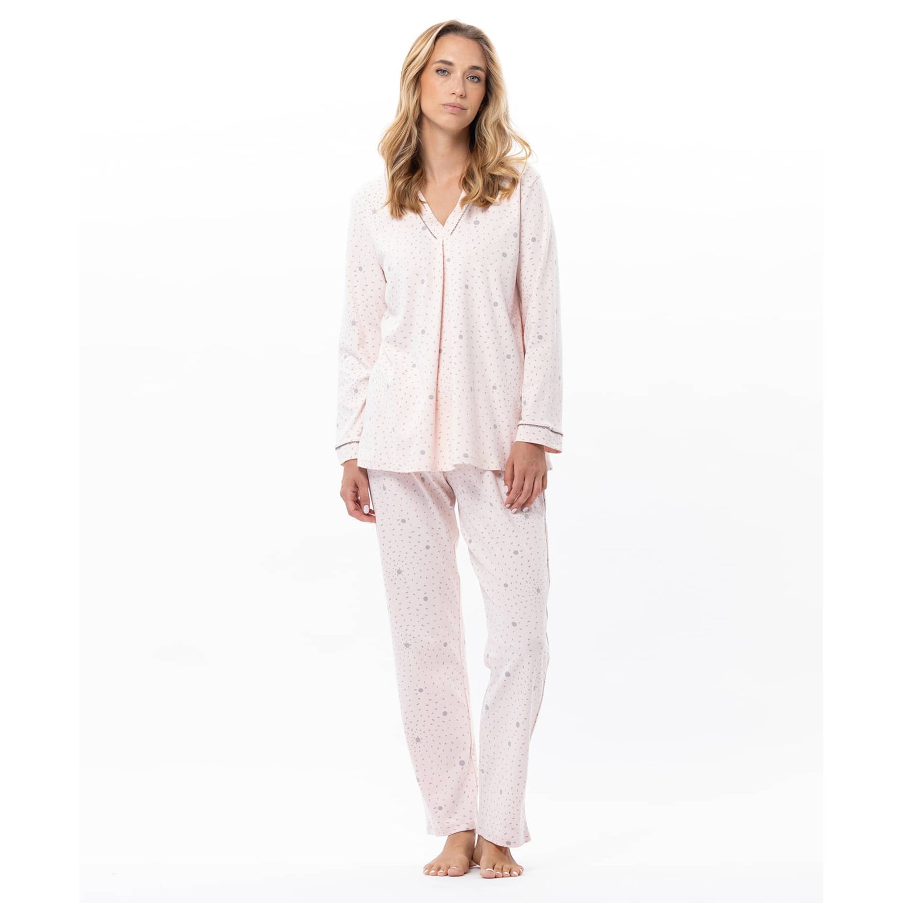 Woman wearing a light pink pajama set on a white background