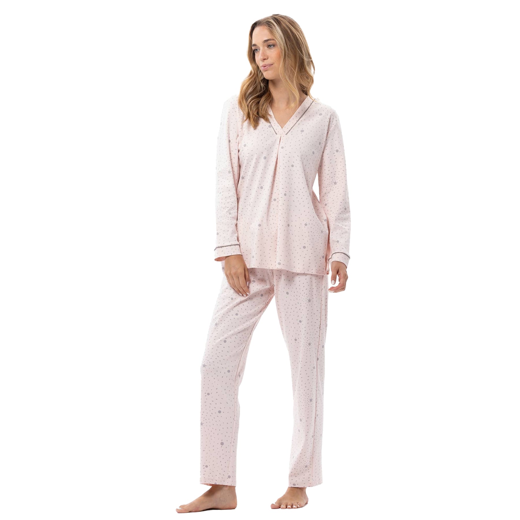 Woman wearing a light pink pajama set with a subtle pattern on a white background