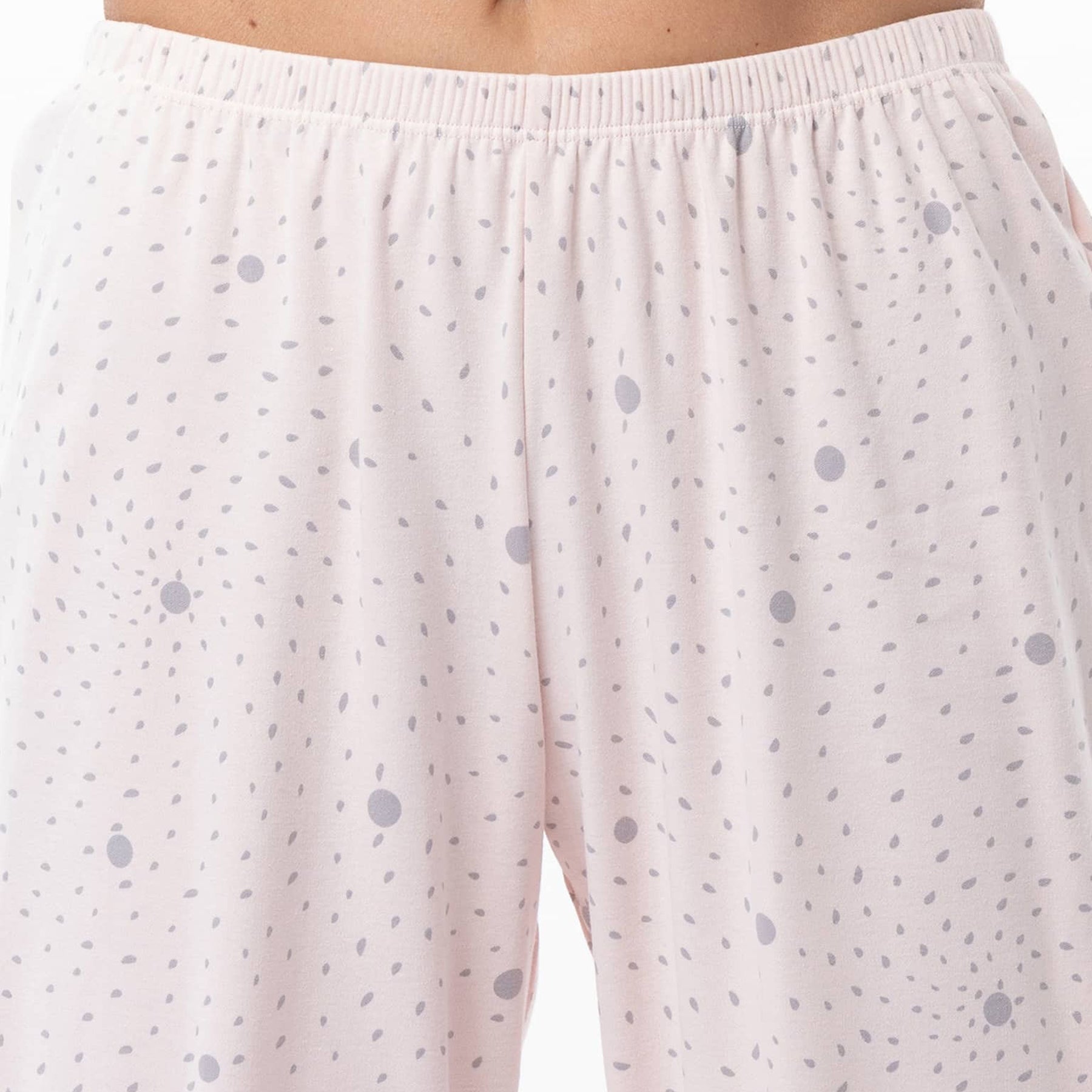 Light pink pajama pants with small gray dots on a plain background