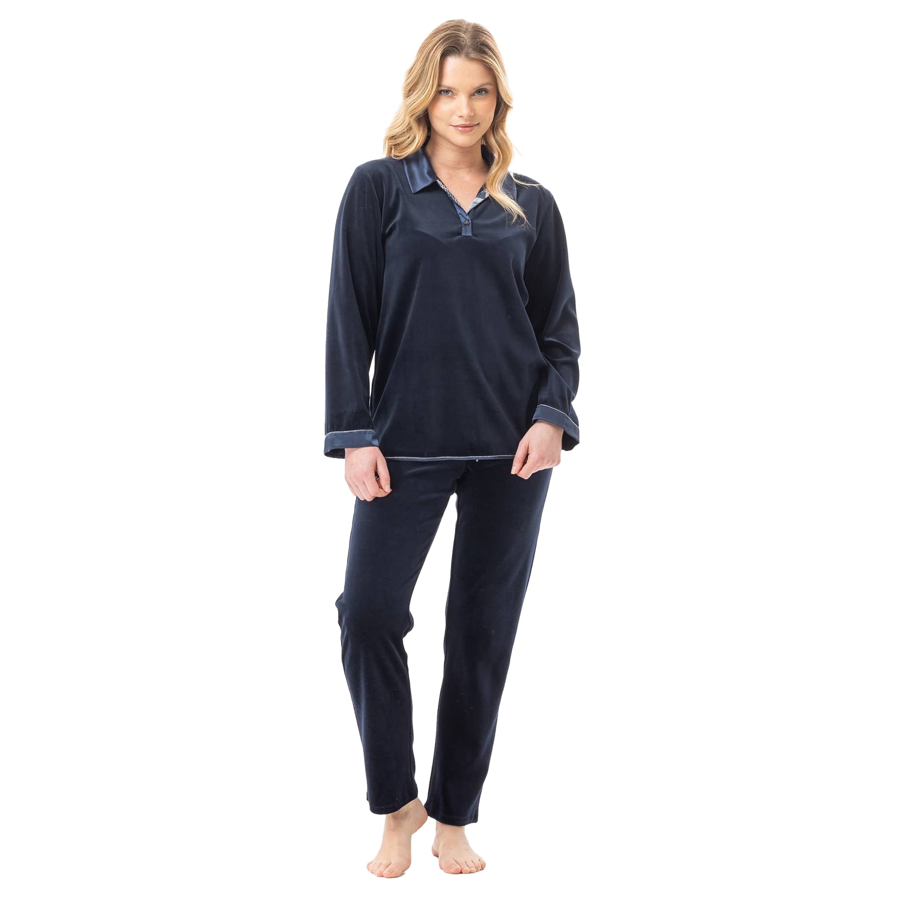 Woman posing in dark blue velour pyjamas with long sleeves and straight-leg pants.