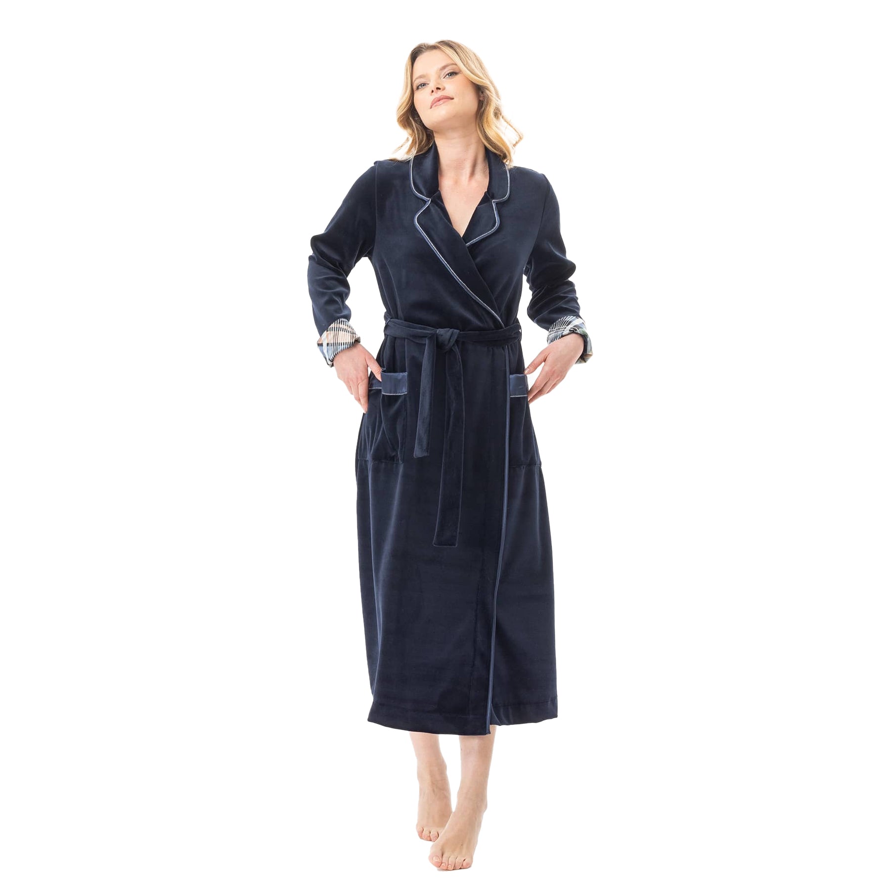 Woman wearing a navy velour robe with satin piping and plaid cuff accents, tied at the waist.