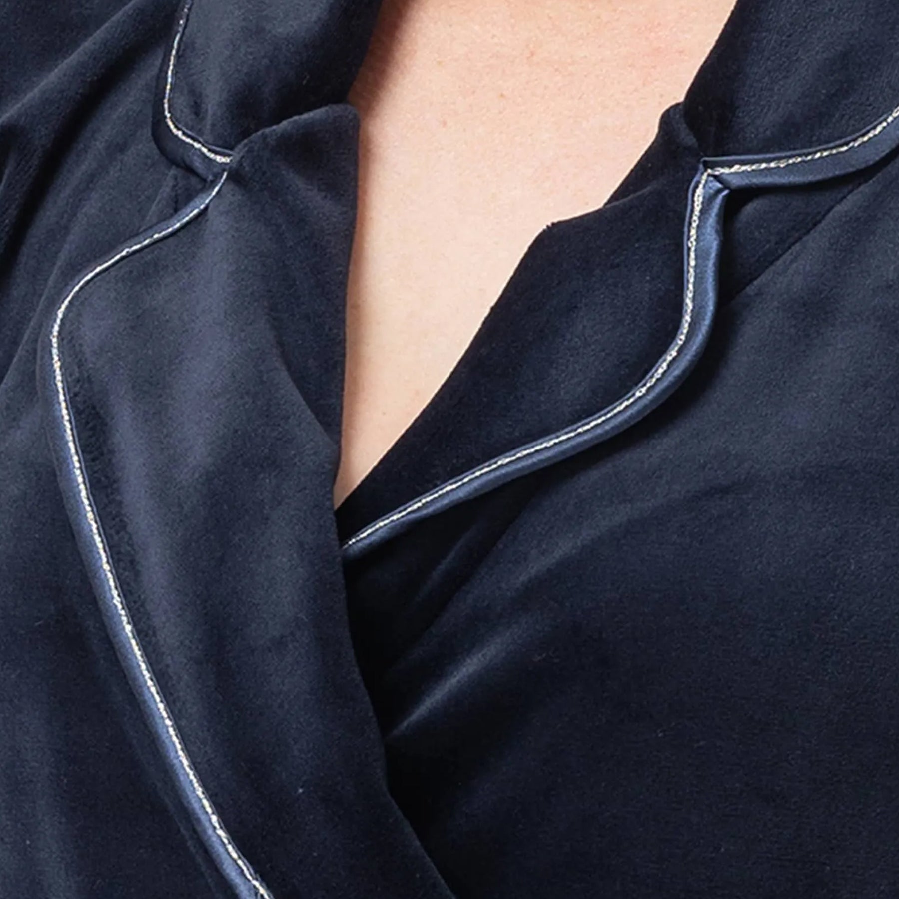 Close-up of satin piping detail on the navy velour robe collar.