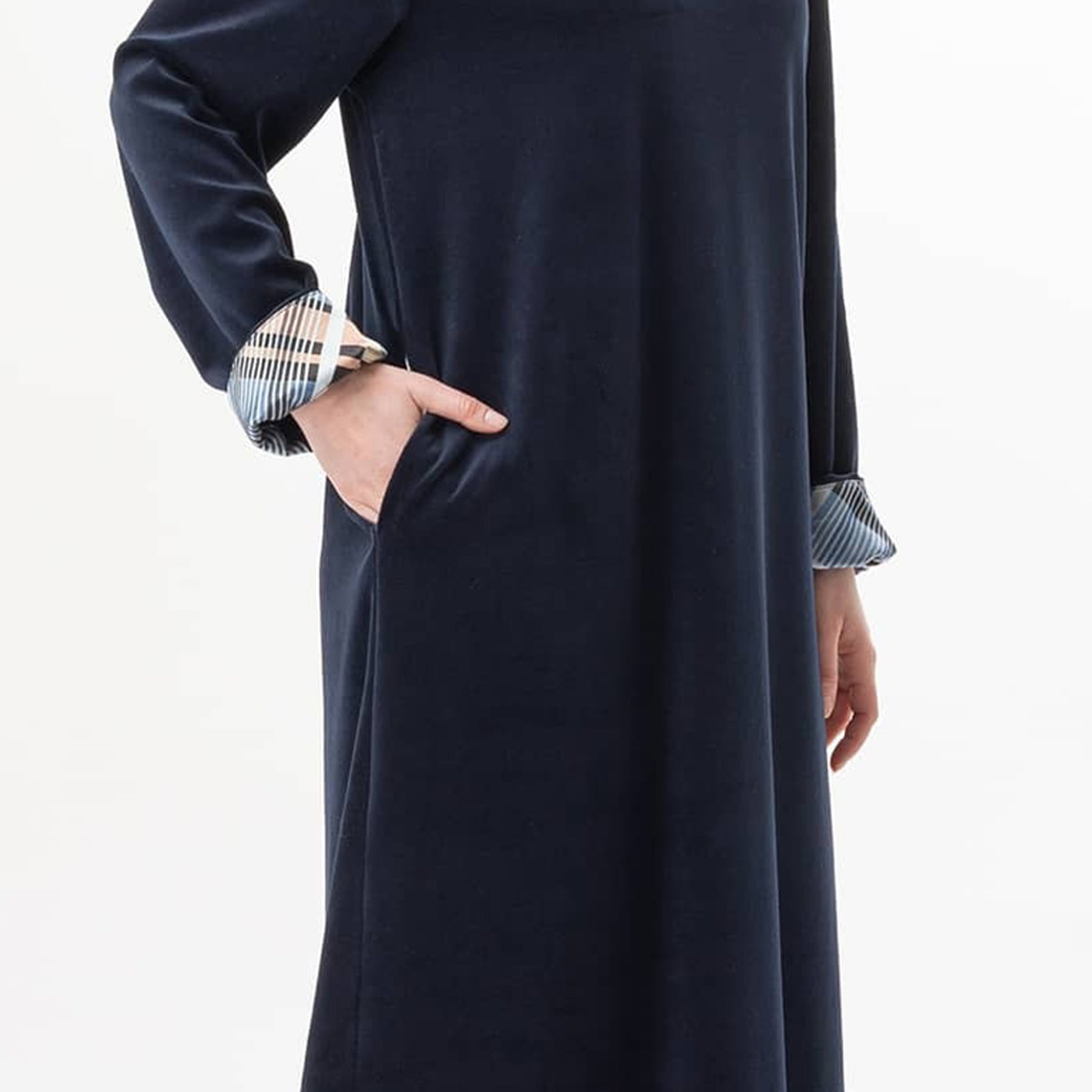 Close-up of side pocket and plaid cuff detail on navy velour gown.