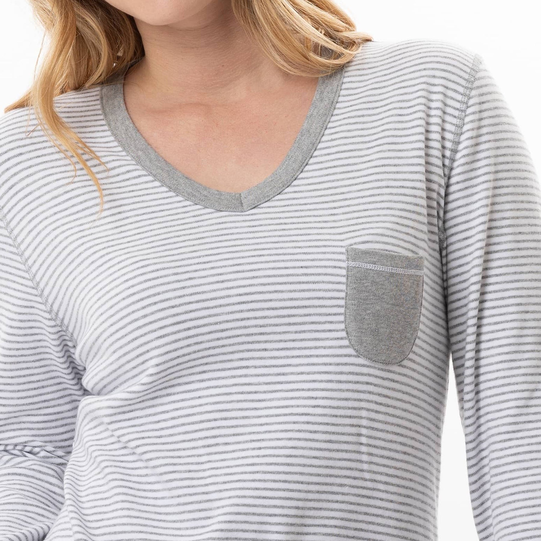 Close-up of a person wearing a gray and white striped long-sleeve shirt with a pocket.
