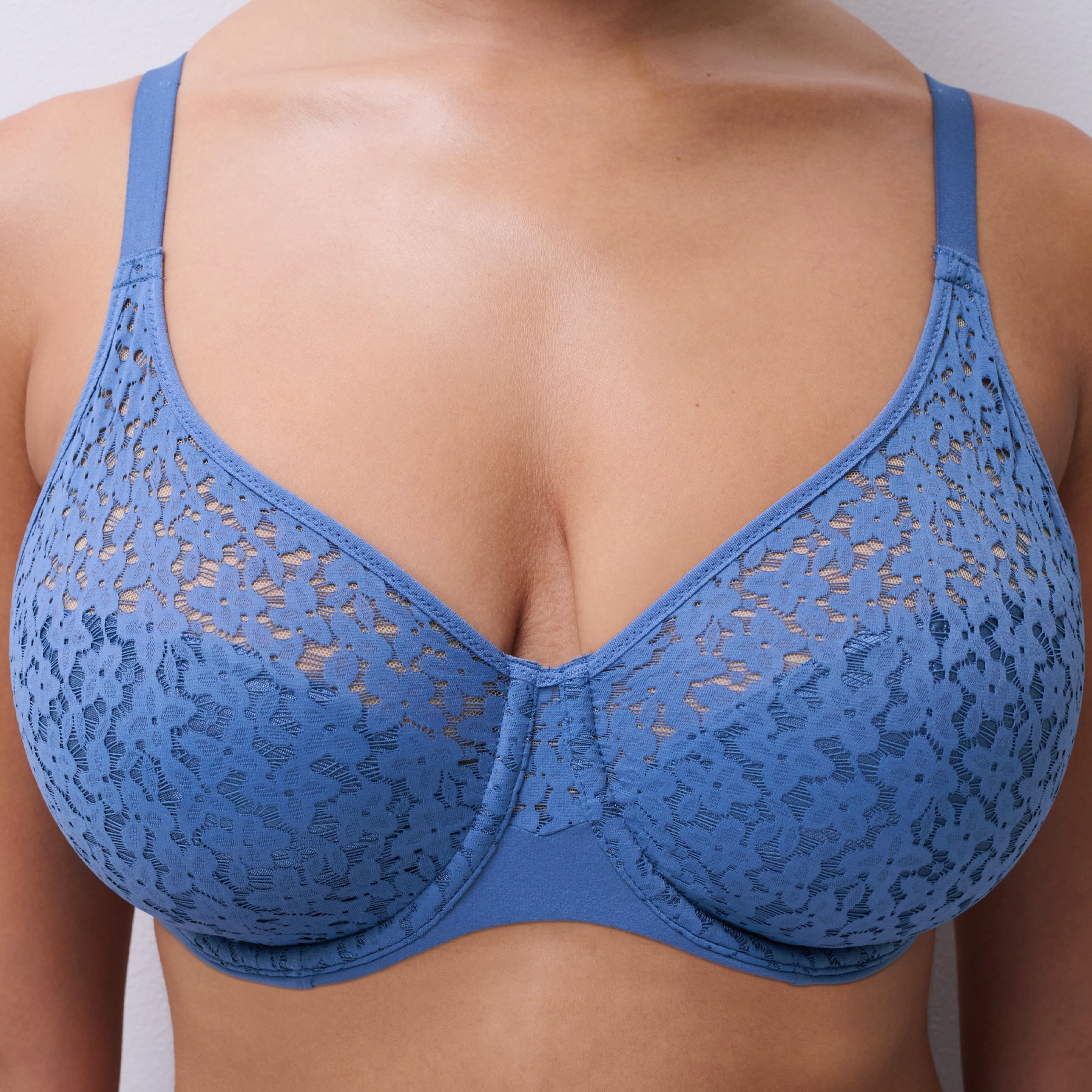Close-up of an ocean blue lace bra featuring floral lace cups, sheer upper panel, and supportive full coverage fit