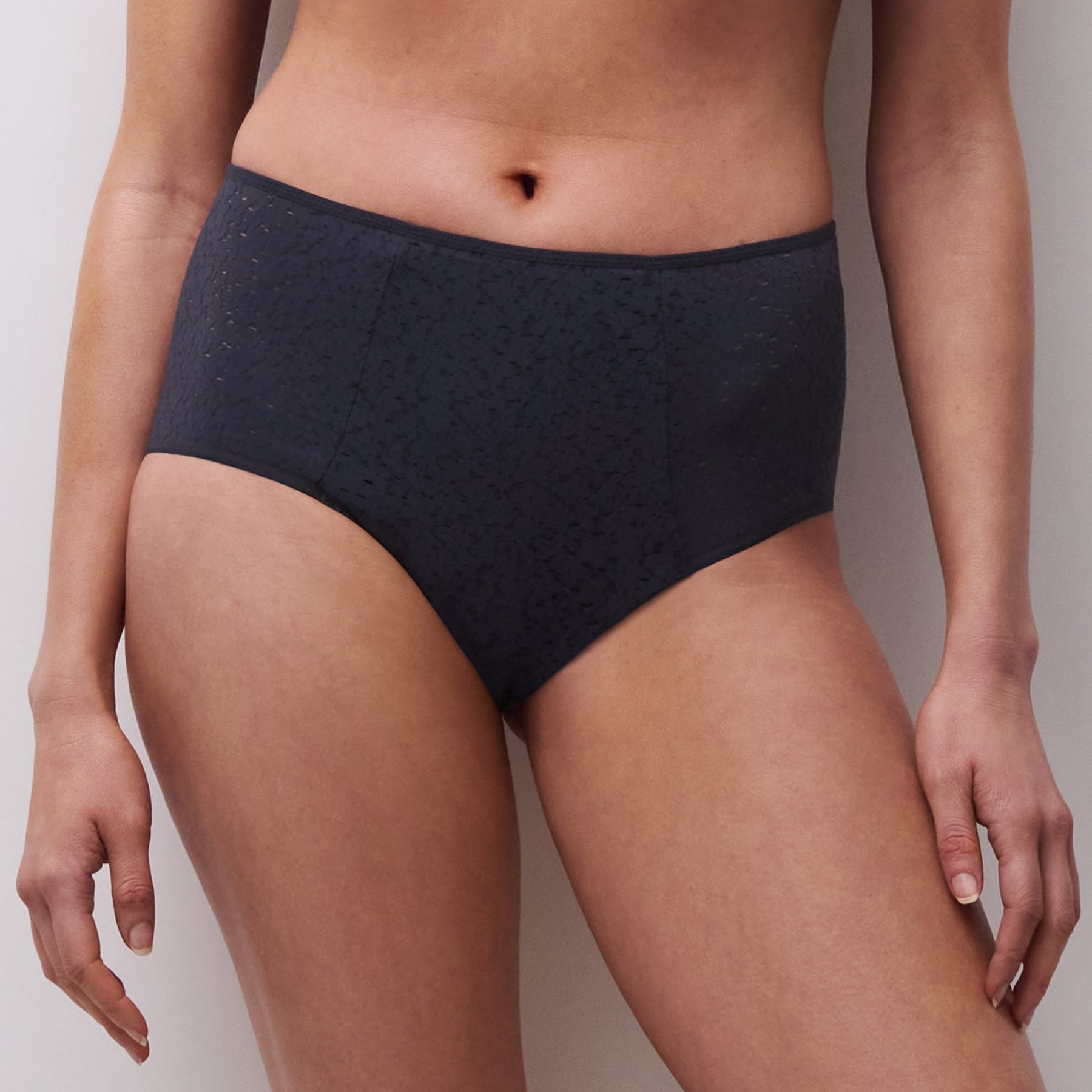 Front view of navy lace high-waisted brief on model showing full coverage and textured fabric.