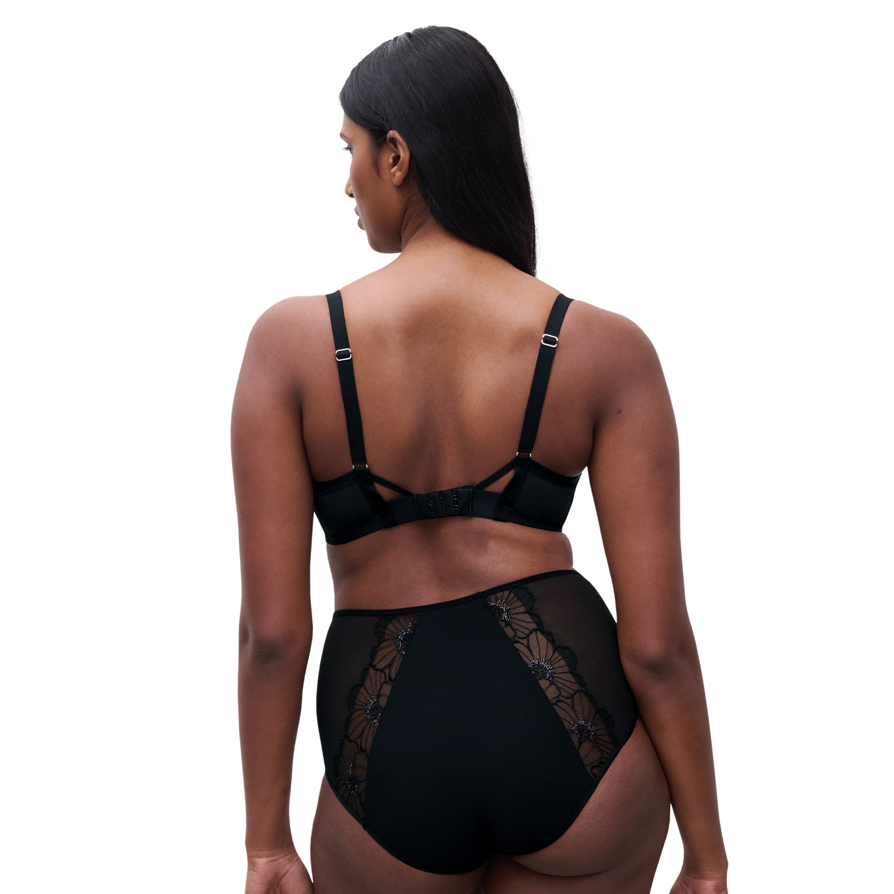 Back view of model wearing black floral embroidered plunge bra and high-waist brief with sheer floral panels.