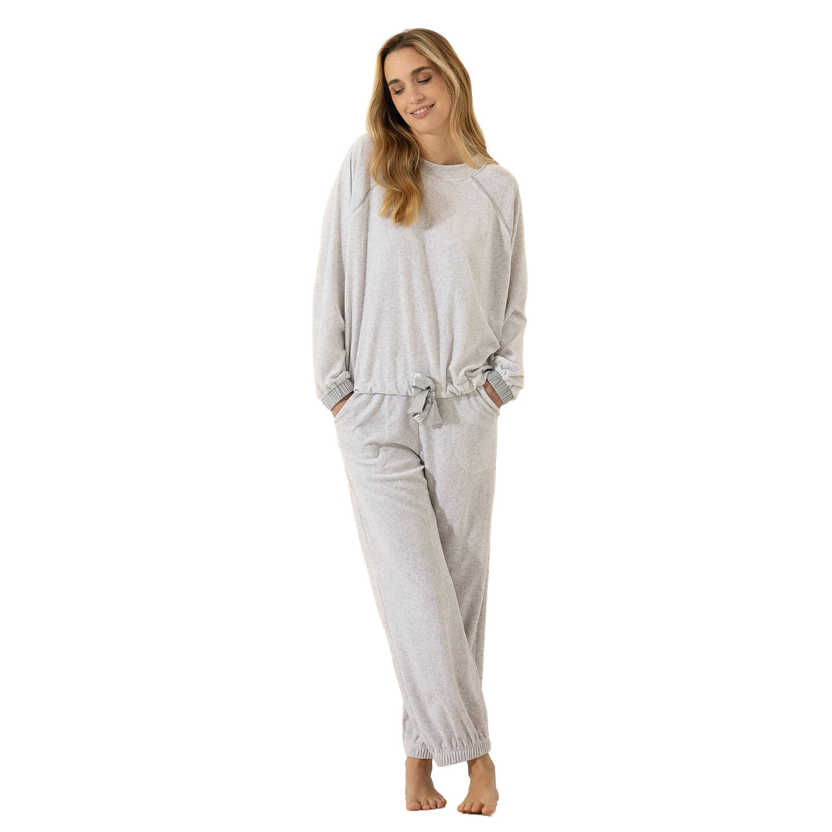 Woman wearing a soft light grey lounge set with a relaxed long-sleeve top, tie-front hem, and matching jogger pants.