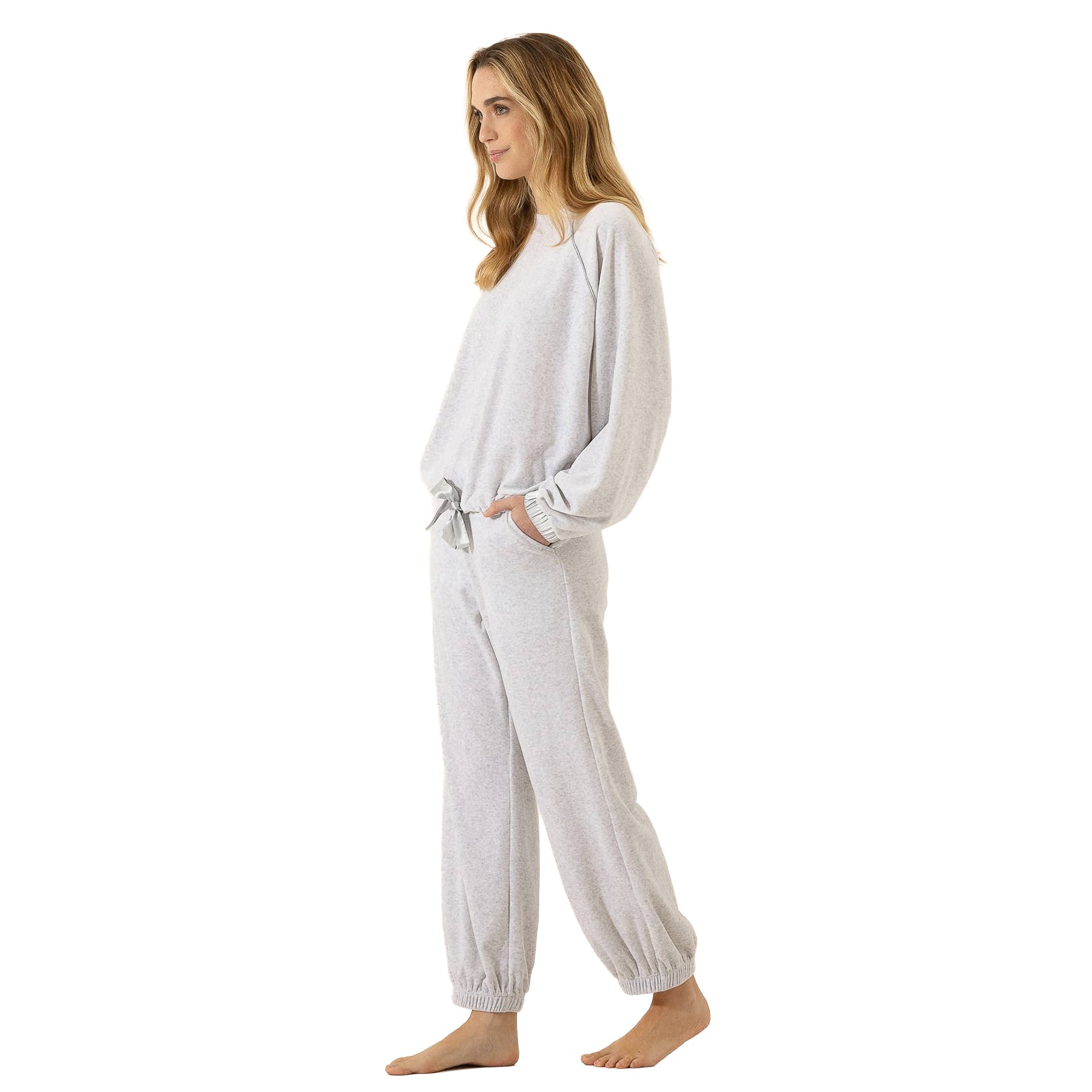 Side view of woman wearing a soft light grey two-piece lounge set with long sleeves, side pockets, and elastic ankle cuffs.