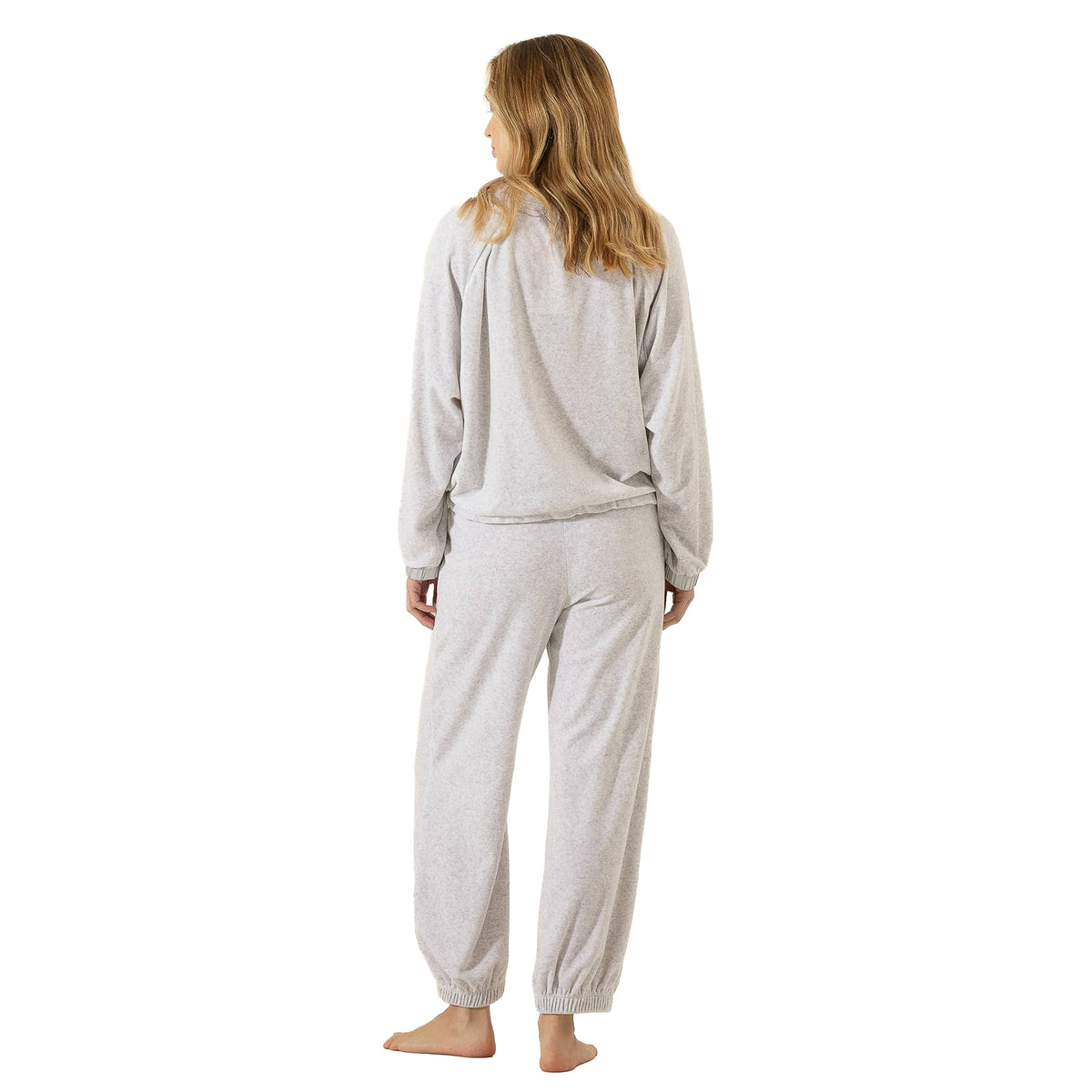 Back view of woman wearing a light grey lounge set with a relaxed long-sleeve top and matching jogger pants.