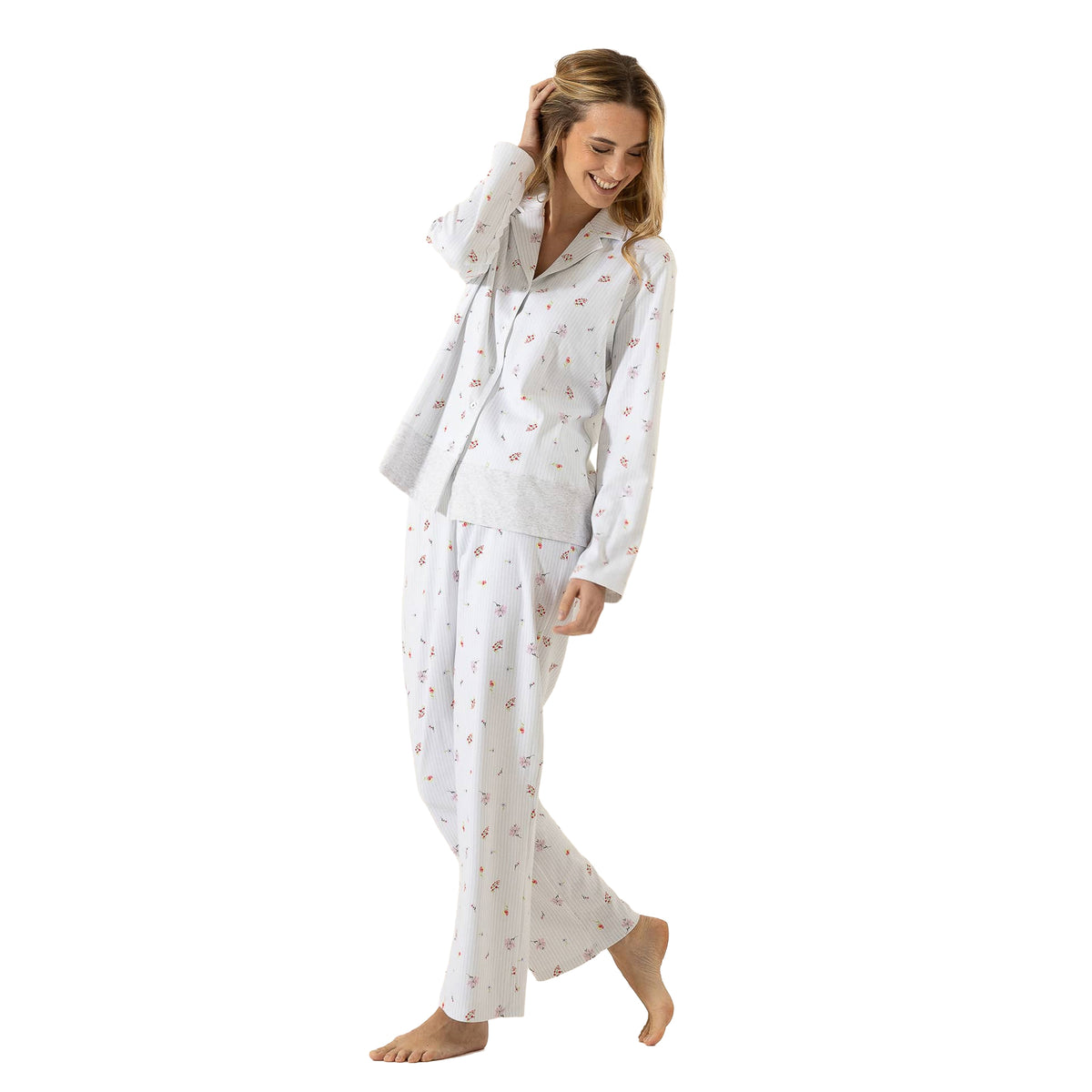 Woman wearing a white mini floral pajama set featuring a button-front collared top, contrast hem, and relaxed matching pants.