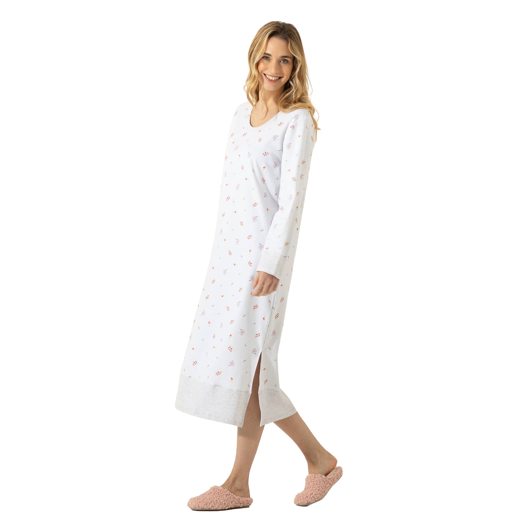 Woman modeling a long white floral nightgown with scoop neckline, long sleeves, grey contrast hem, and side slit.