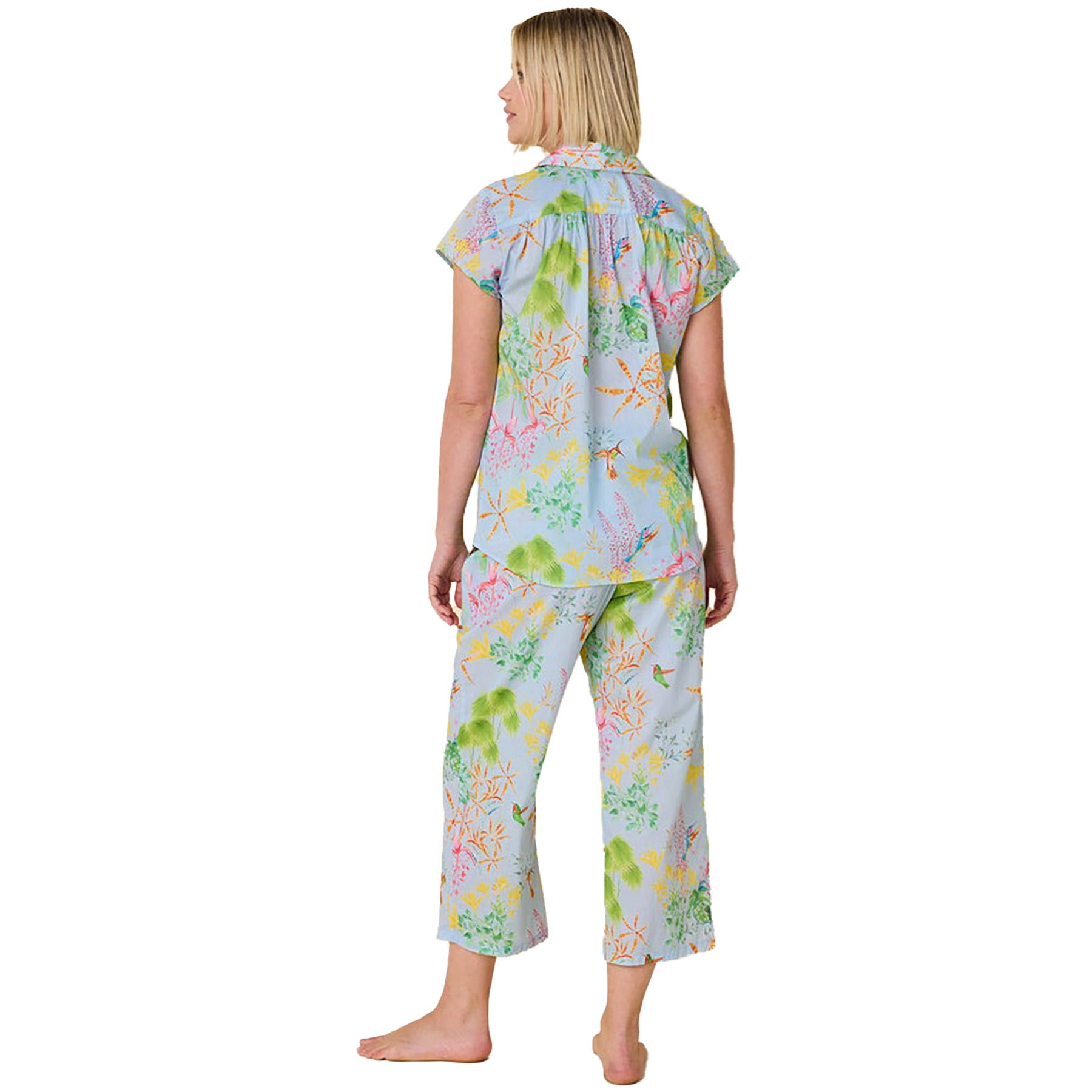 short sleeve button up pajamas with matching capri pants in a multicolour hummingbird print on a blue background. Rear view on model.