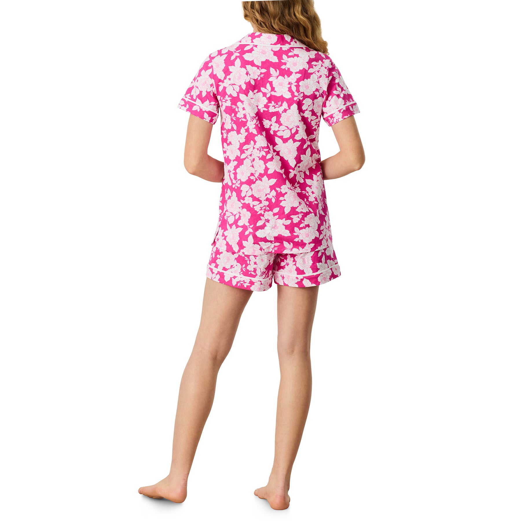 Flat lay of Carole Hochman raspberry floral pyjama set with button-up top and drawstring shorts on white background