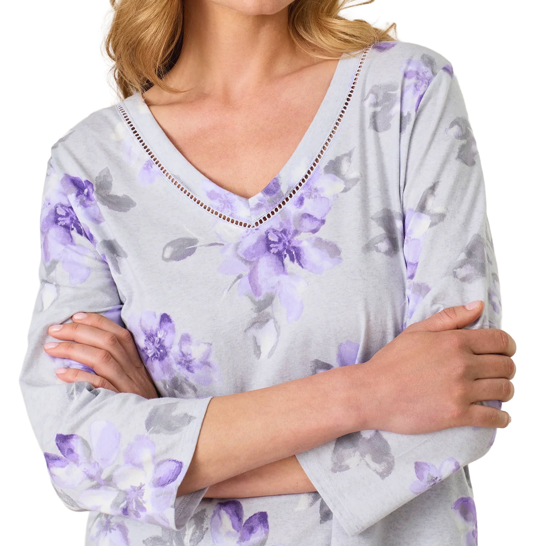 Close-up of the grey floral pajama top showing the purple watercolor flower print and delicate openwork trim along the V-neckline.
