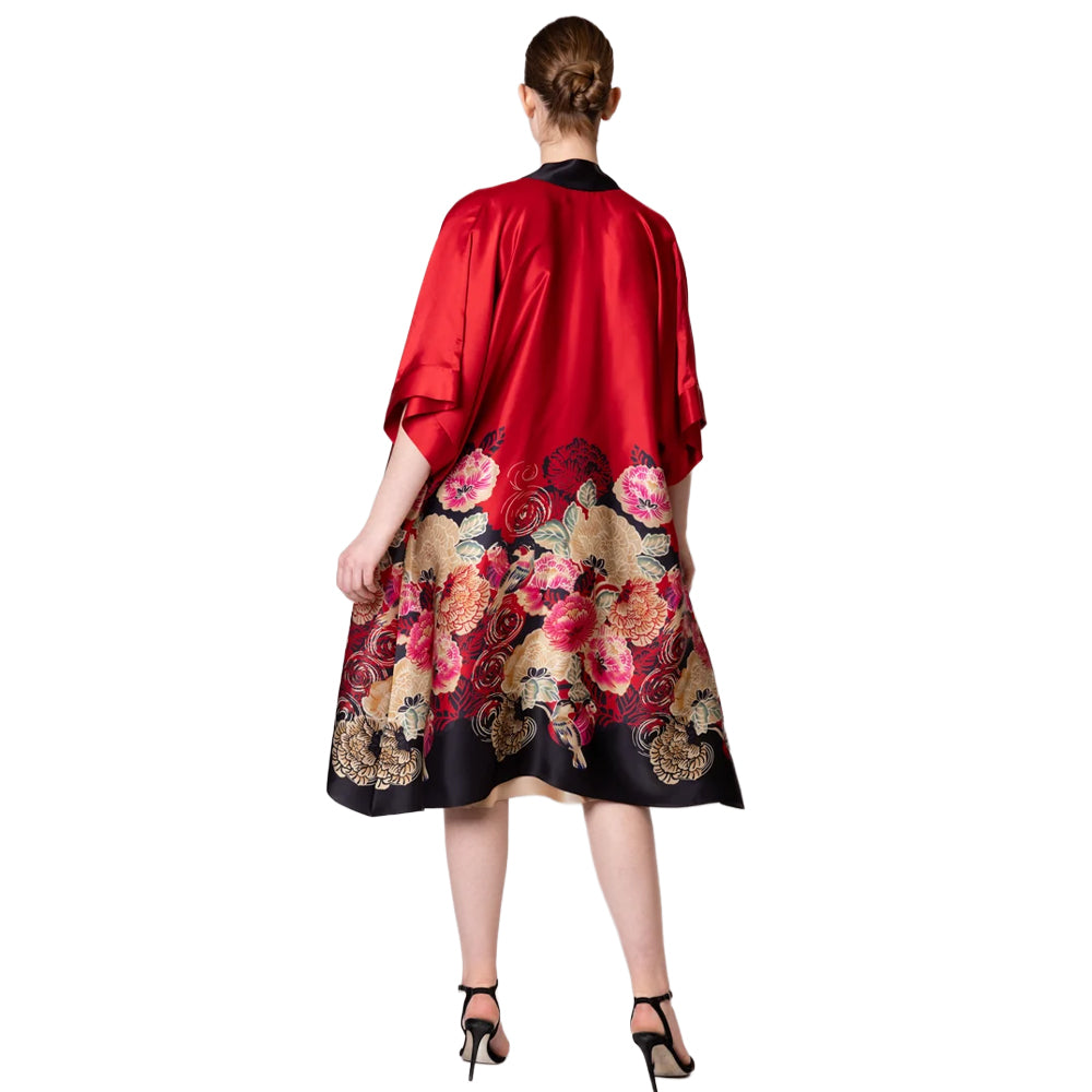 Back view of Christine Crimson Moon Kimono featuring flowing red satin, a vibrant floral and bird print, black hem, and relaxed kimono sleeves.