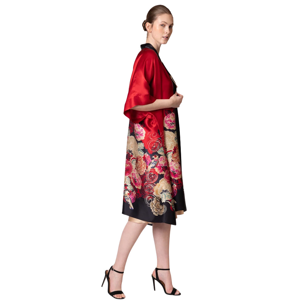 Side view of Christine Crimson Moon Kimono showcasing its loose, flowing silhouette, elbow-length sleeves, black satin trim, and colourful floral print.