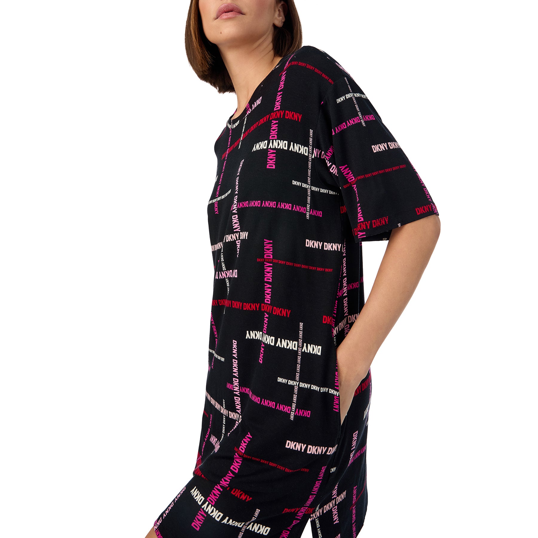 Short sleeve round neck sleepshirt in black with DKNY logo print in shades of pink. Side view close up on model.