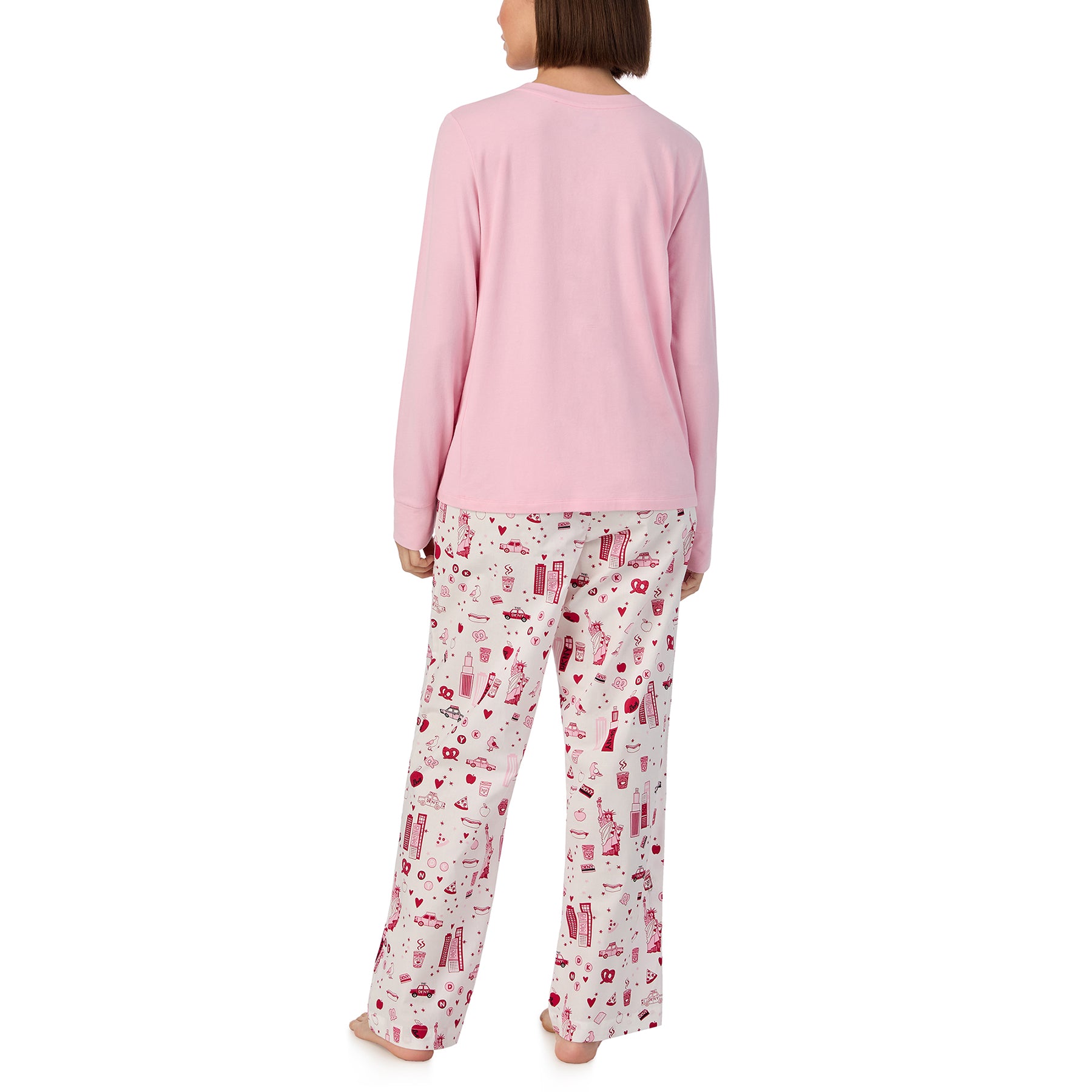 Long sleeve solid pink lounge top with matching pants printed with new york city items in red and pink on a white background. Rear view on model.