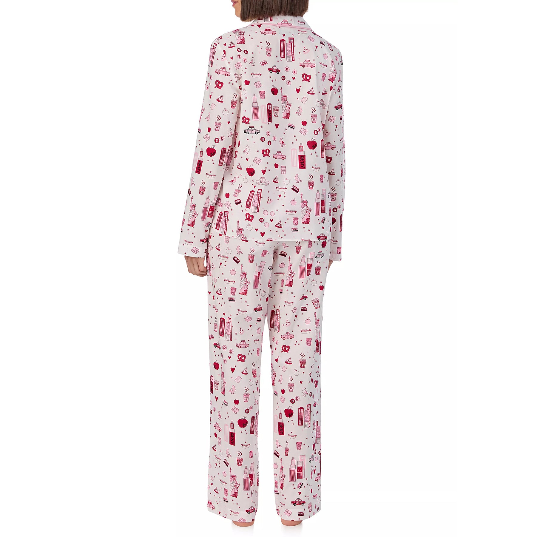 Classic 2-piece button up pyjama set printed with new york city items in red and pink on a white background. Rear view on model.