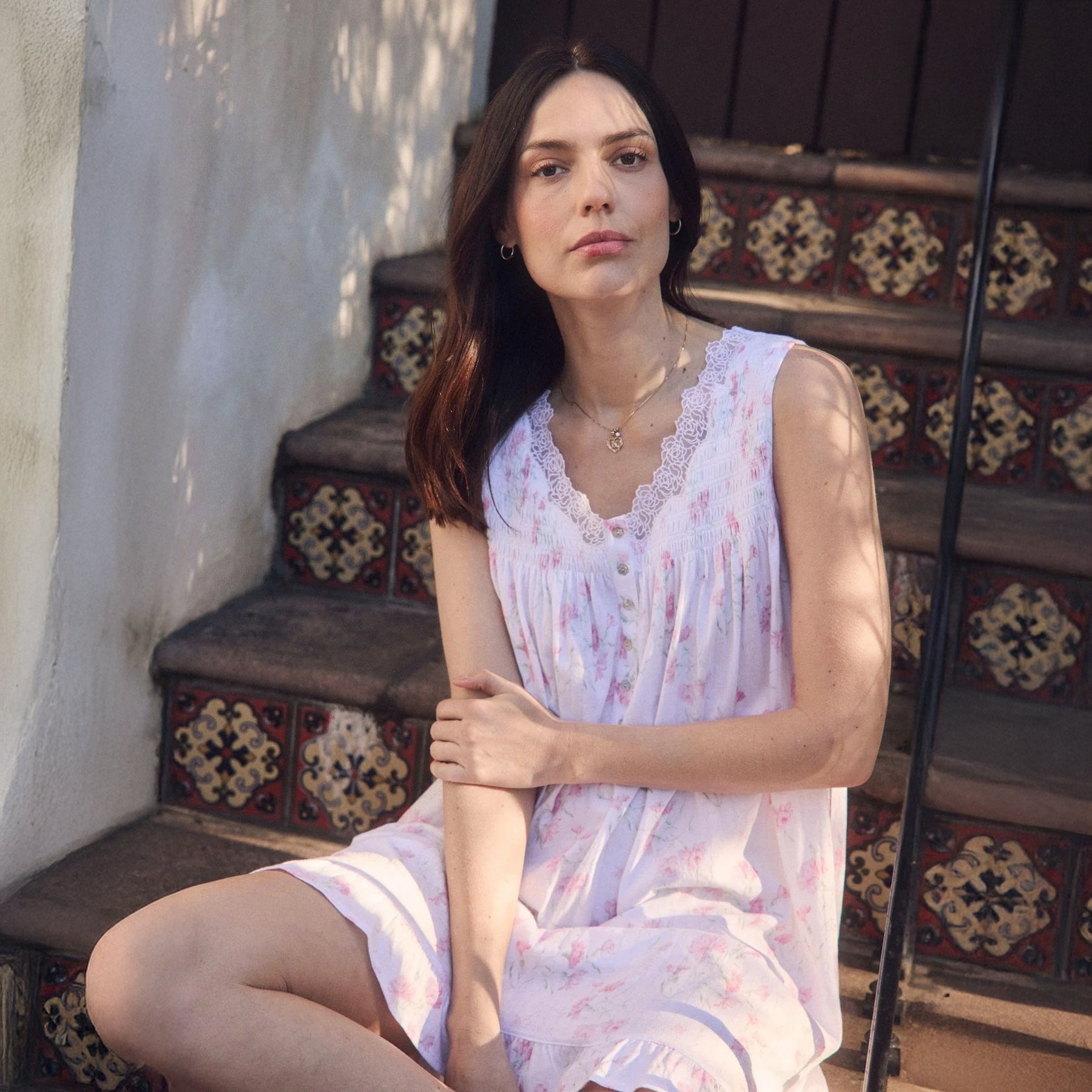 Woman wearing Eileen West floral sleeveless nightgown in soft pink print with lace trim neckline and ruffle hem.