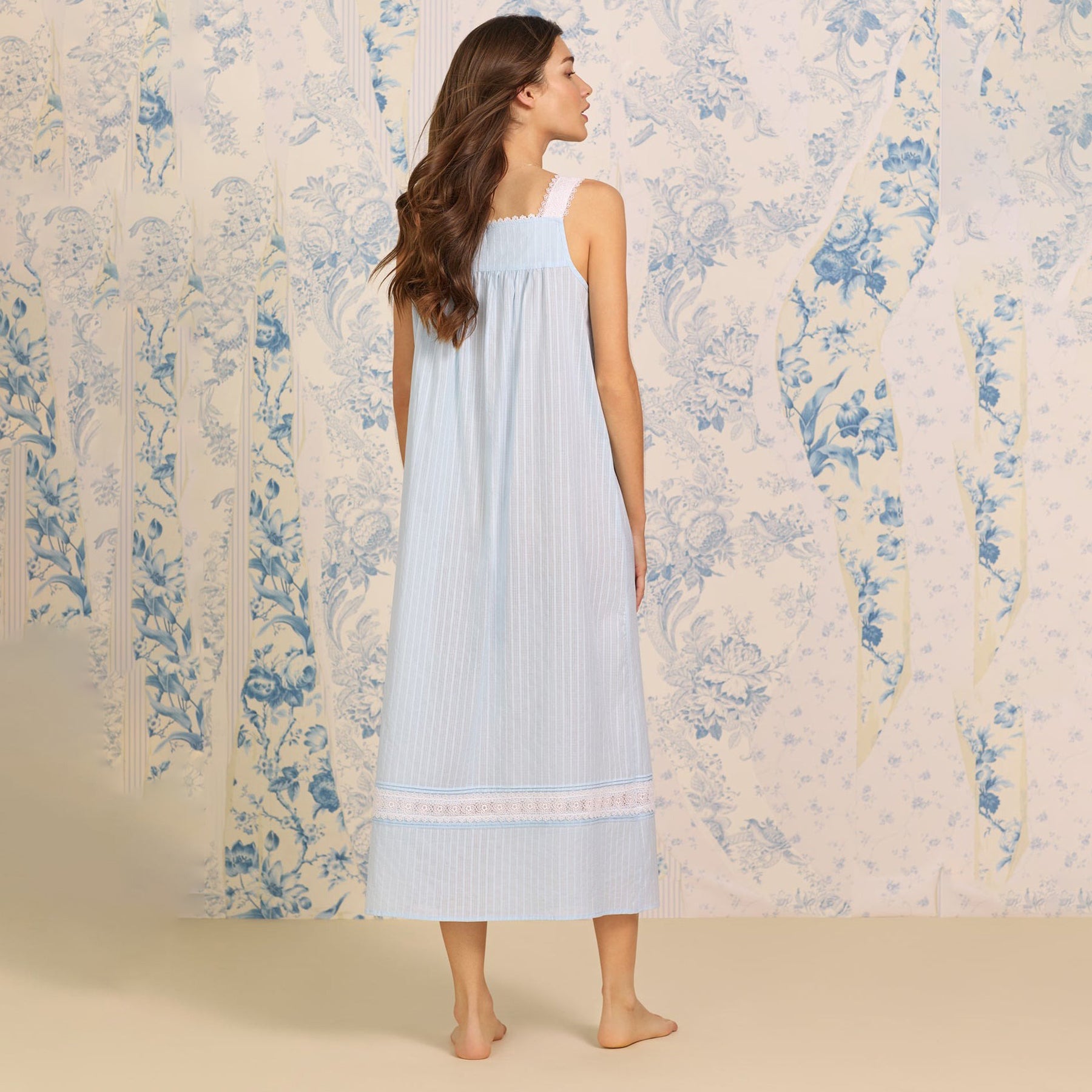 Back view of a women's floral nightshirt in a cottage blue, showcasing intricate lace trim, button detailing.