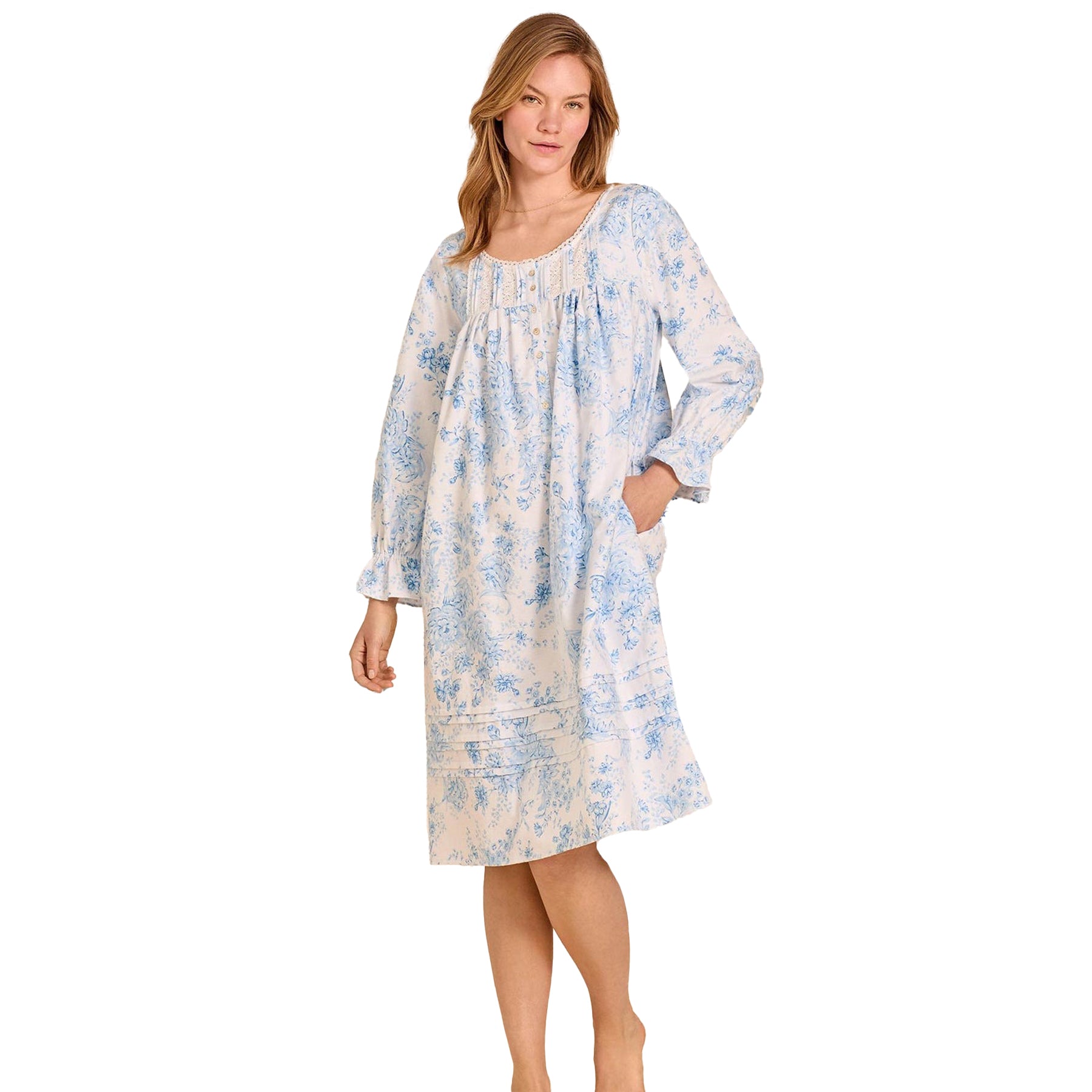 Woman wearing Eileen West long-sleeve cotton nightgown in blue floral print with lace-trim neckline.