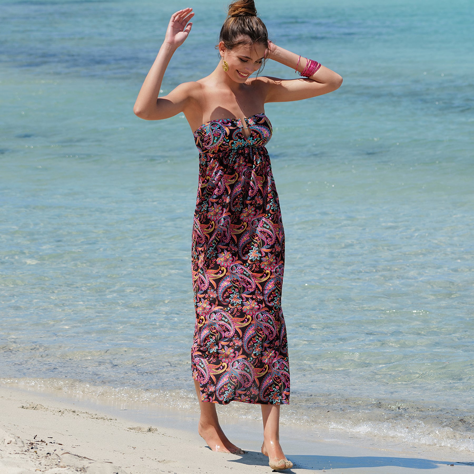 A fashion photoshoot with a close-up view at the swim dress showing a metal detail in the middle., front view.