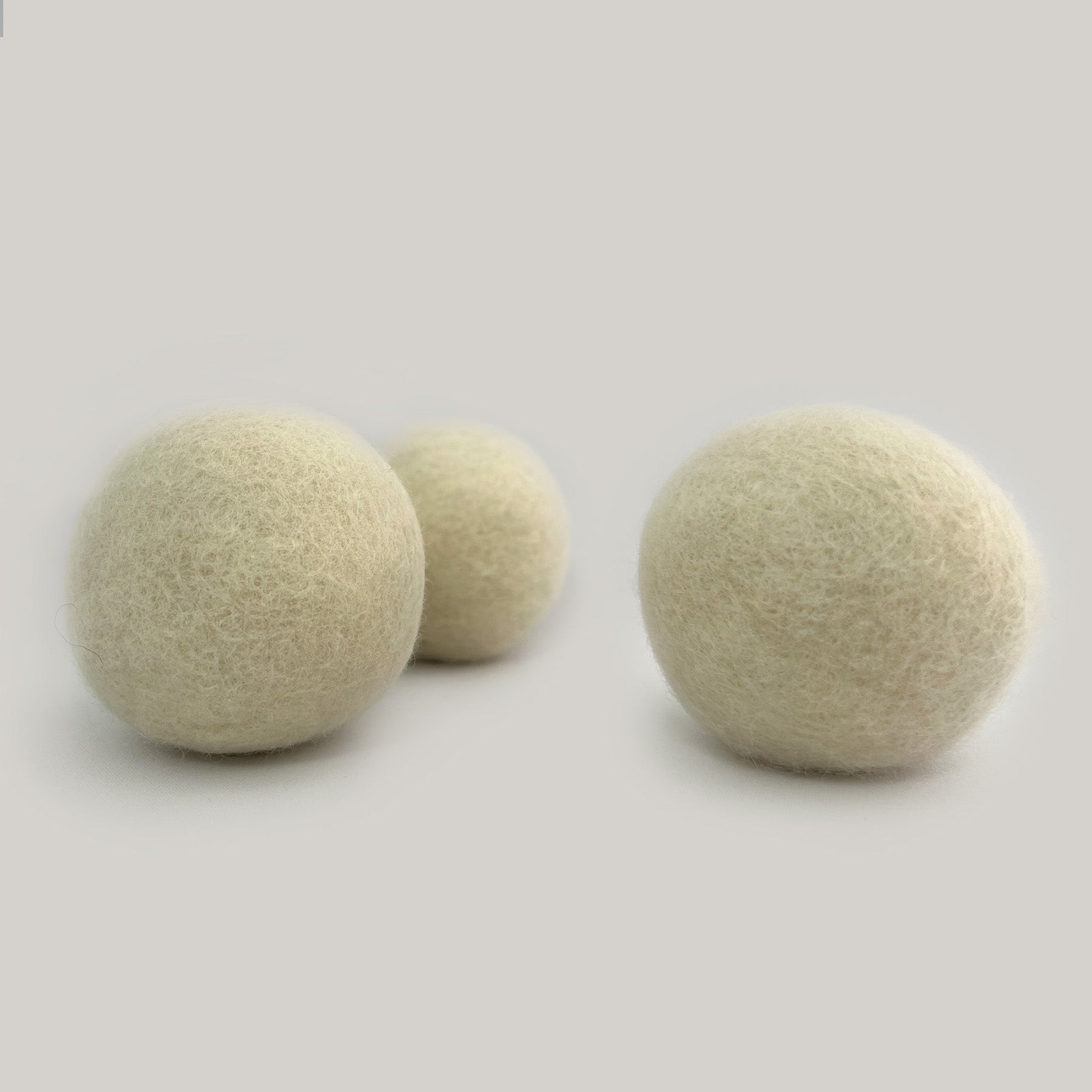 Set of natural white wool dryer balls for laundry, handmade in Canada, eco-friendly and reusable for over 1000 loads.