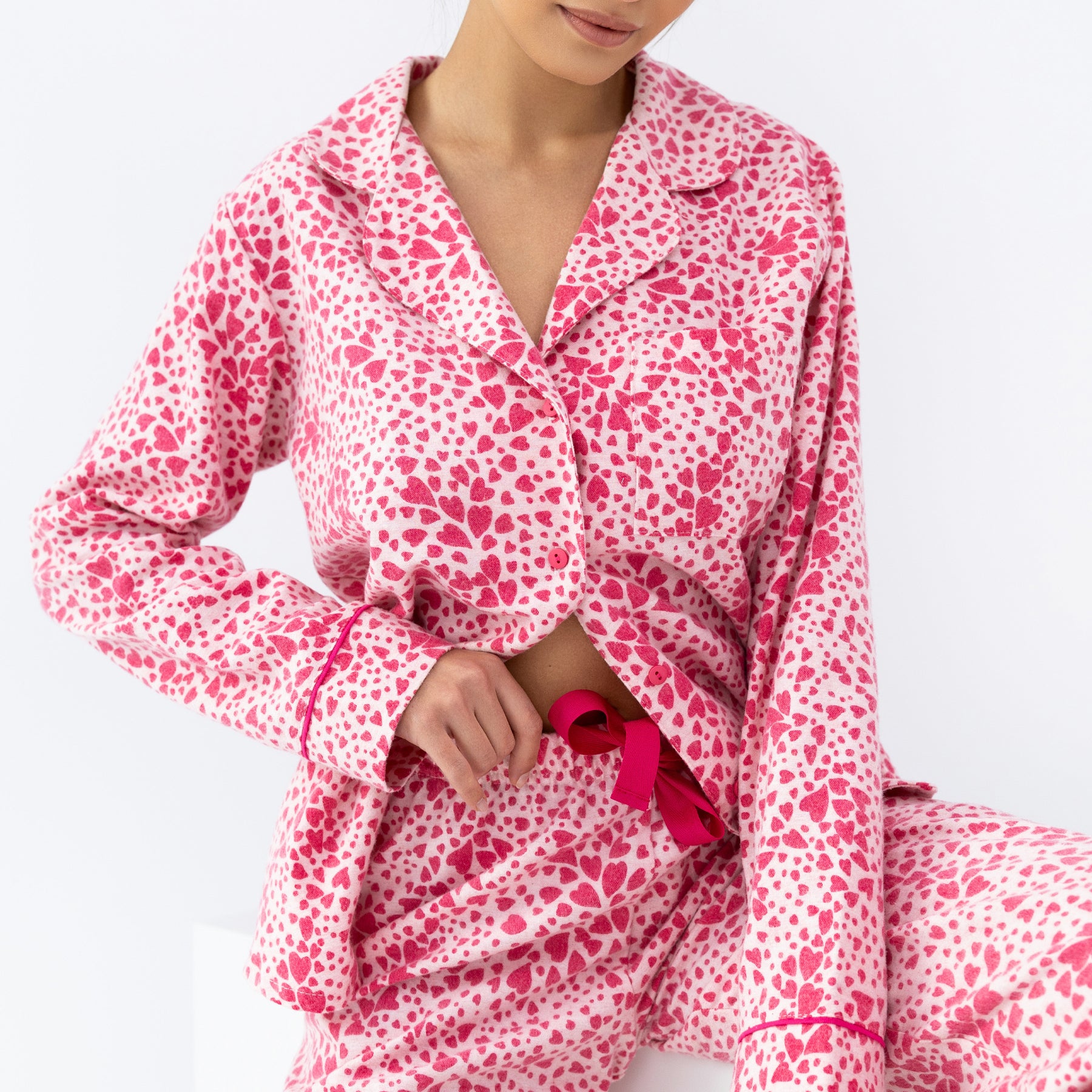 Close-up of pink heart-pattern pyjama top with button front and bright pink drawstring detail.