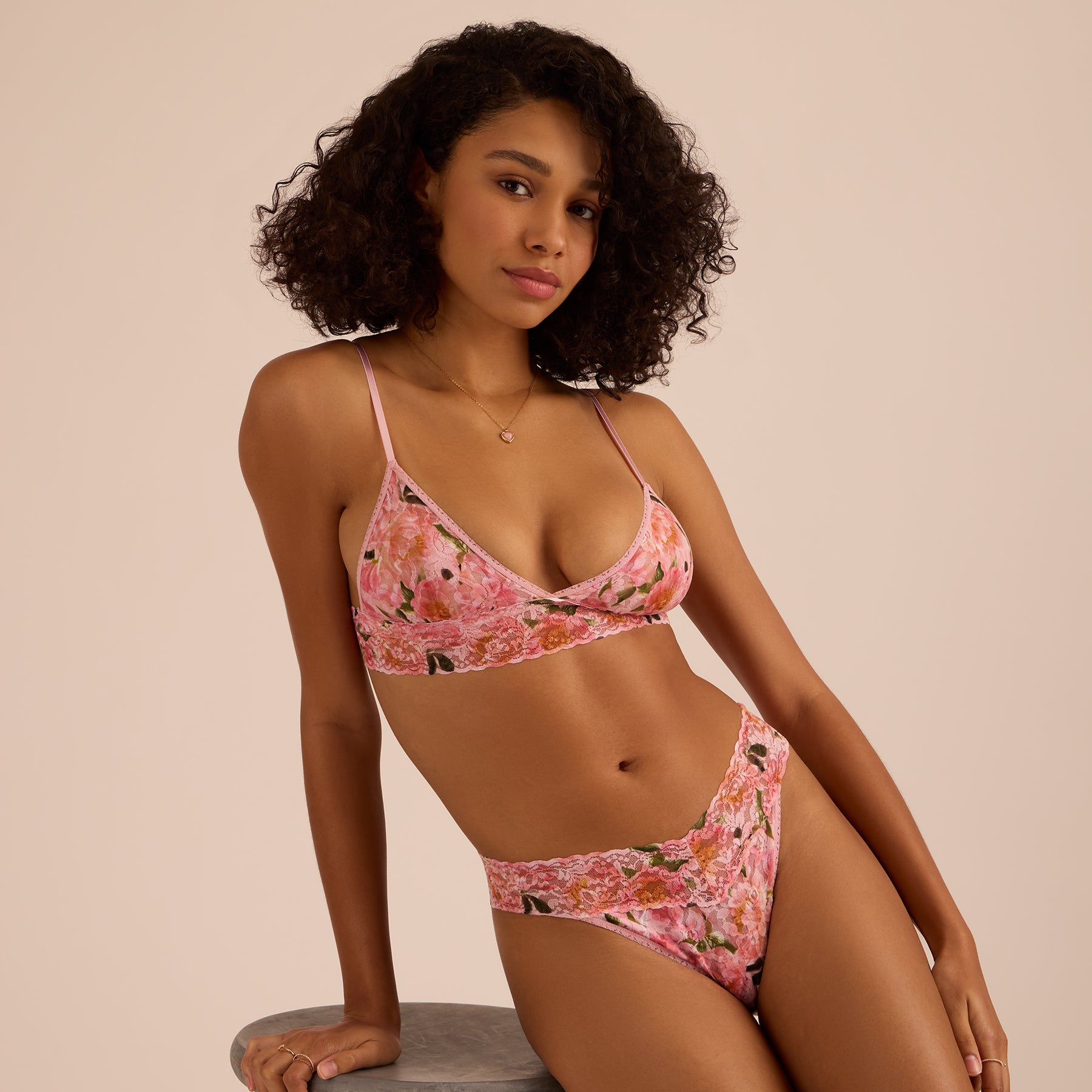 Lifestyle photoshoot of model in pink floral lace bralette and matching original rise thong in the Dancing Petals print