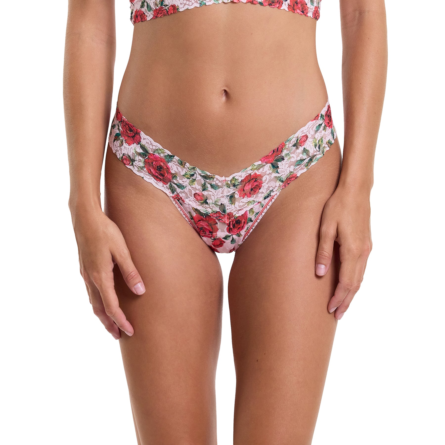 Je t'aime floral red/green rose printed lace low rise thong on a light pink background. Front view on model.