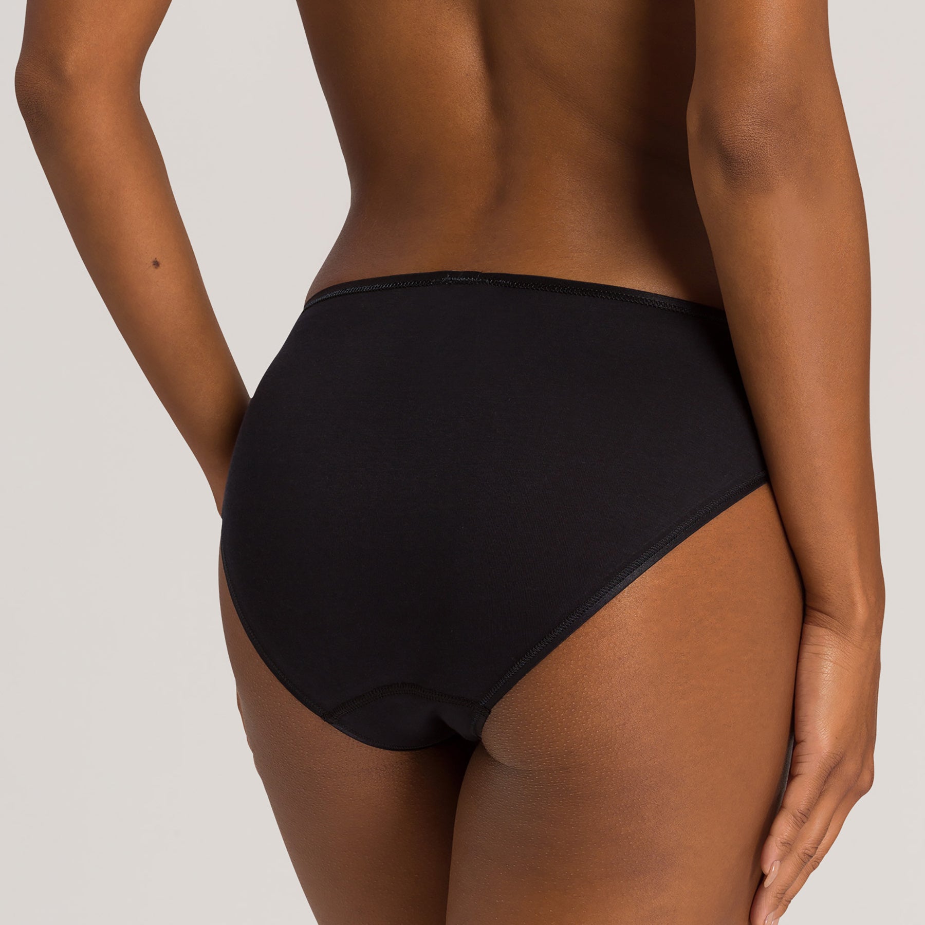 Back view of Hanro Cotton Seamless Bikini Panty in Black with high-cut leg and seamless fit.