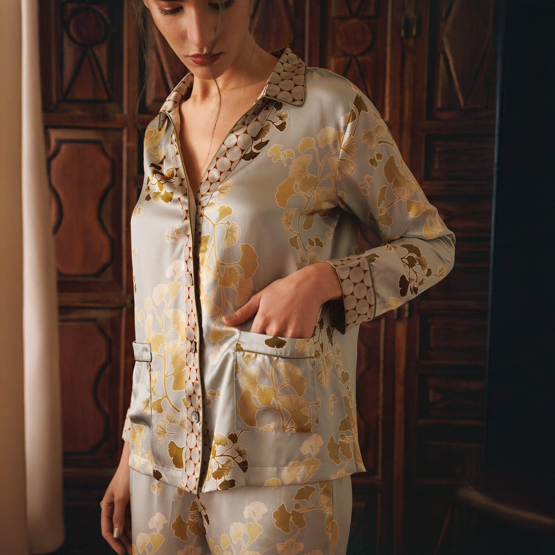 Kazari gold/bronze gingko printed silk classic mother of pearl button up pyjama set. Front view closeup on model.