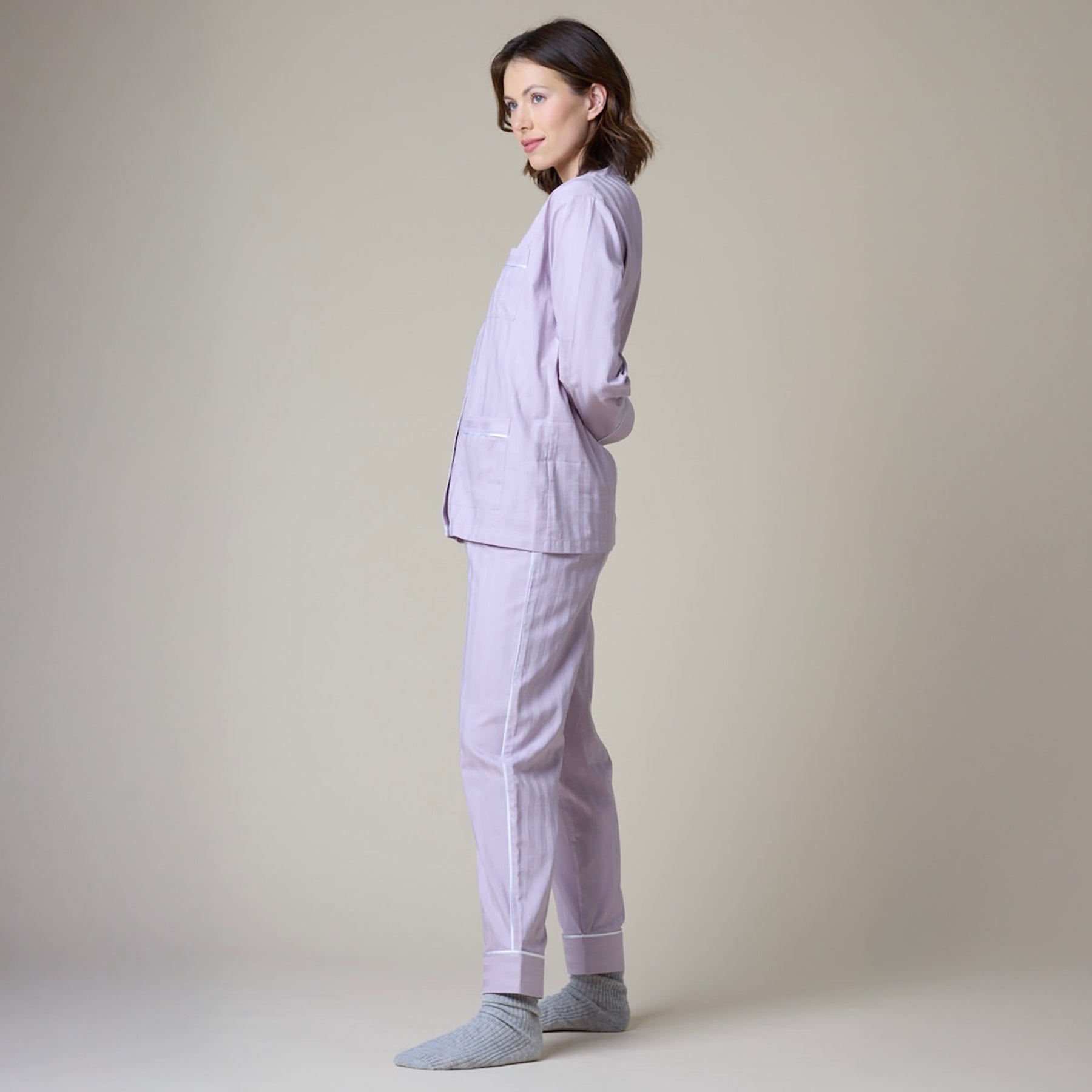 Lavender cotton classic pyjama set with contrast white piping. Side view closeup on model.