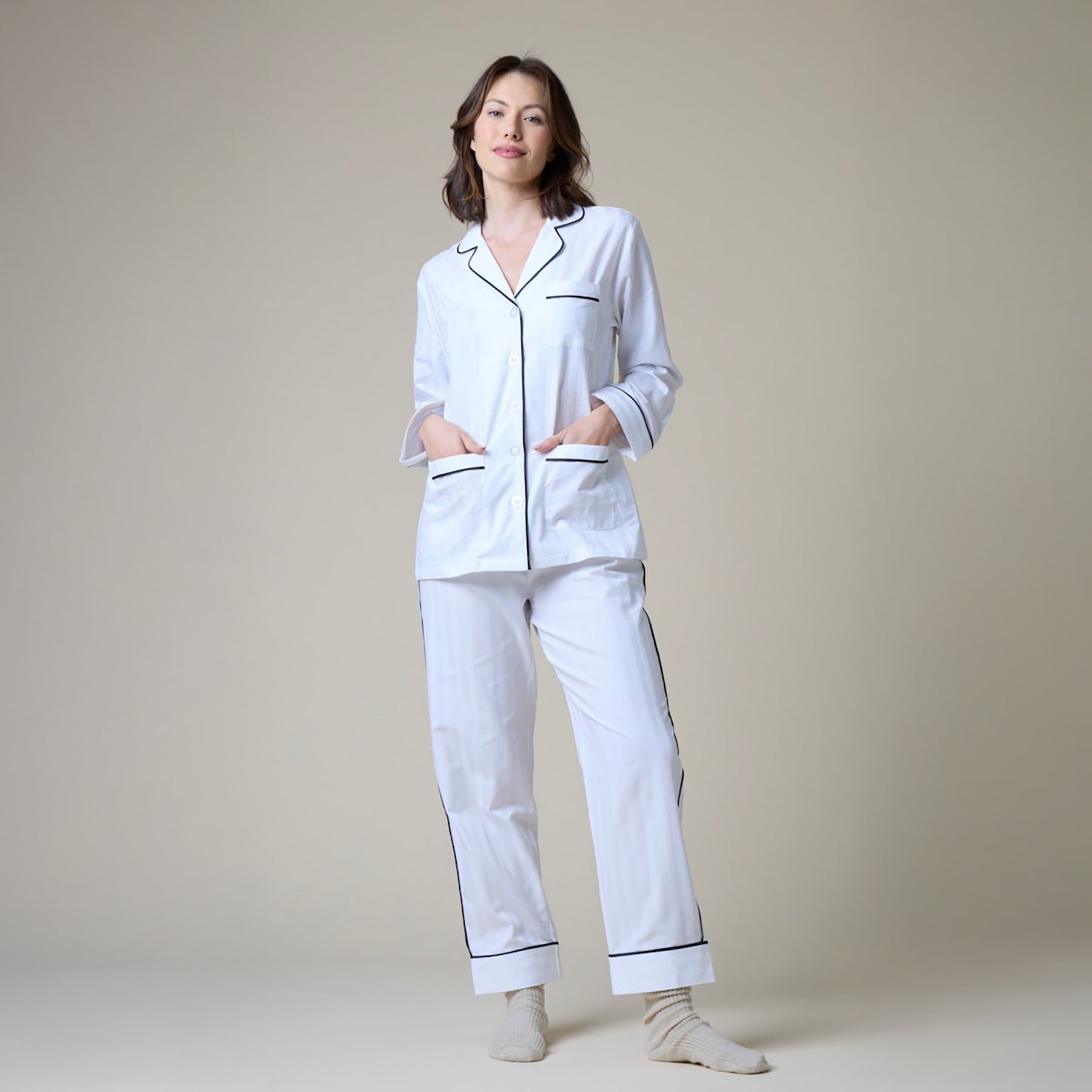 White cotton classic pyjama set with contrast black piping. Front view on model.