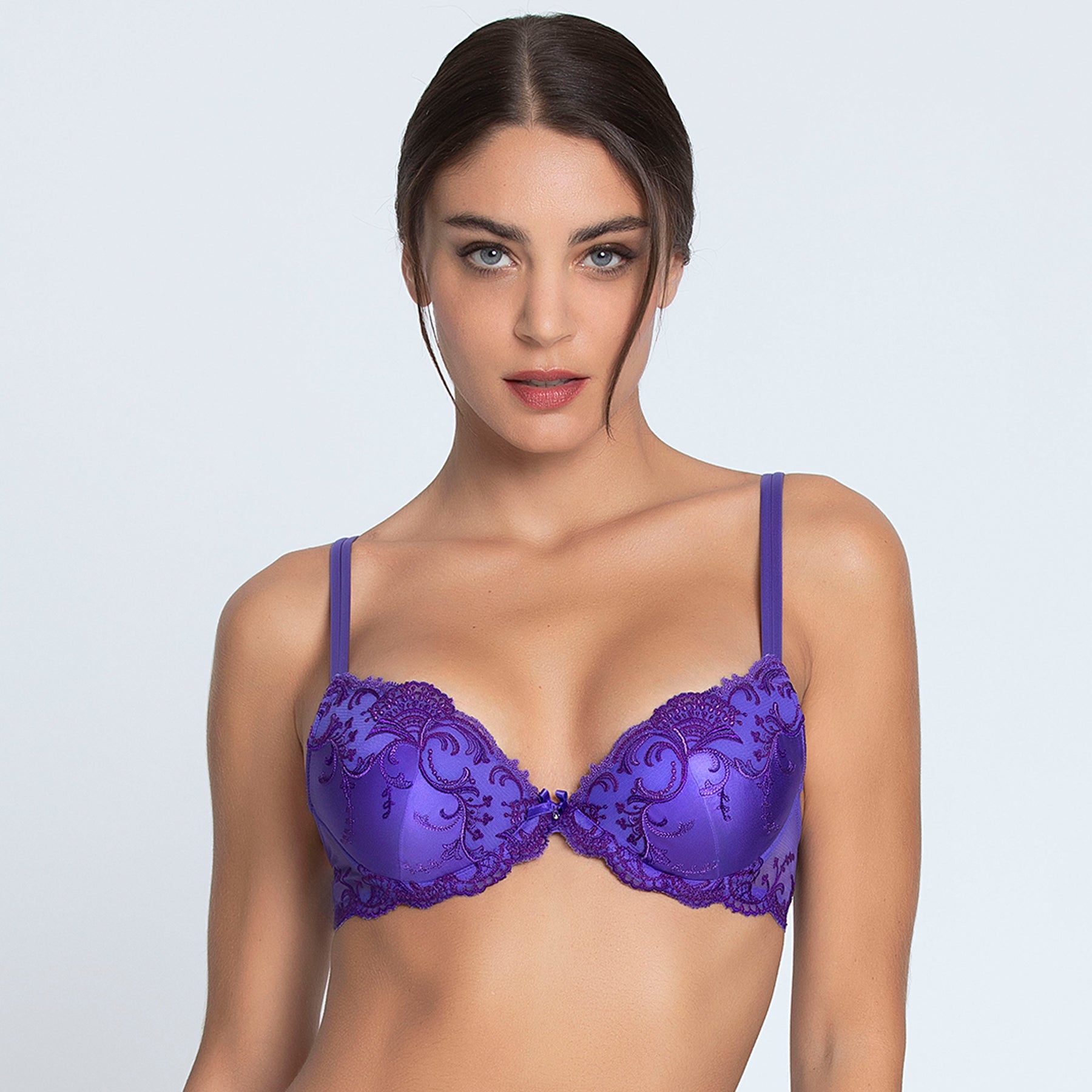 Padded push up contour bra in purple ocean blue with embroidery detail on silk. Front view on model.