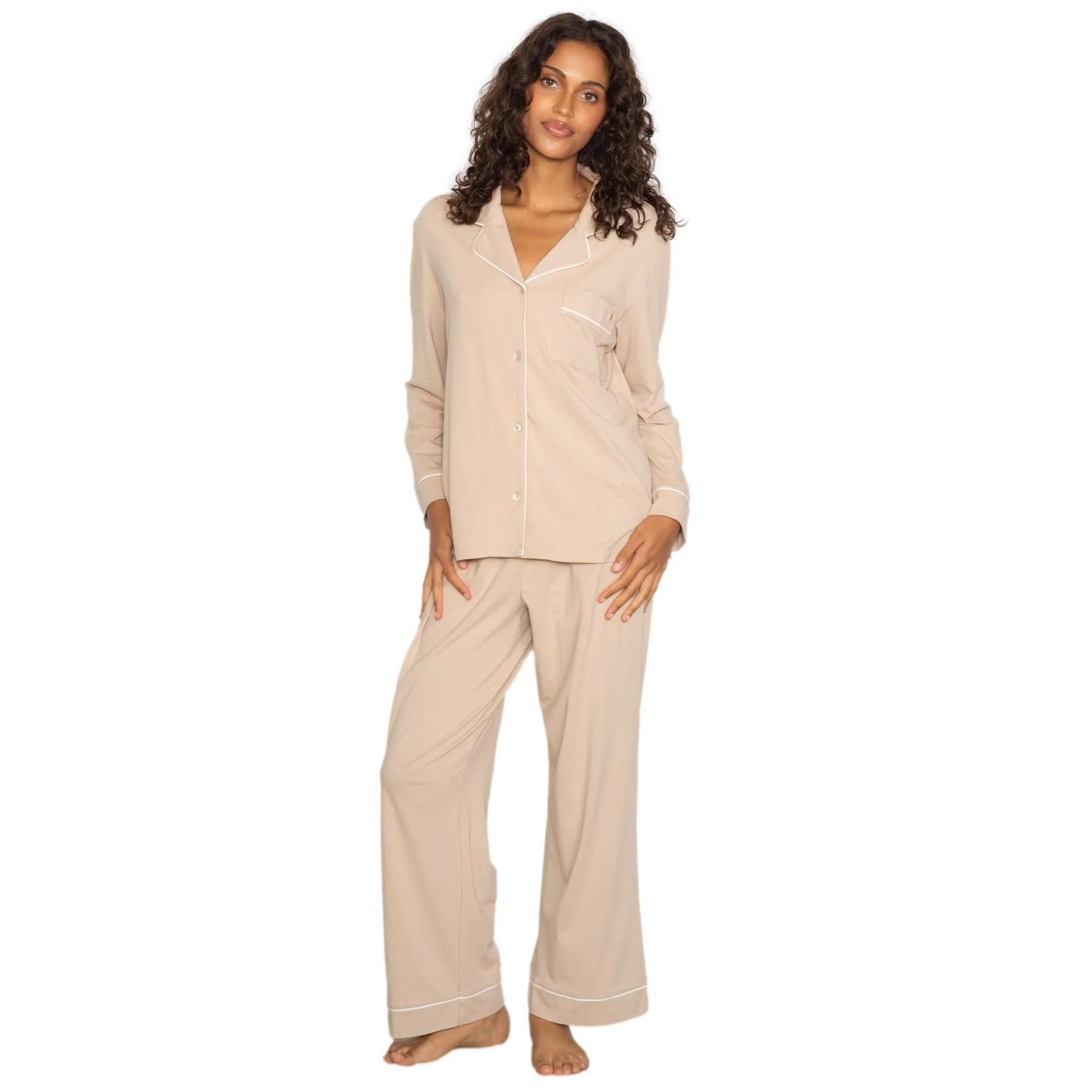 Beige long sleeve pyjama set with button-down top, chest pocket, and wide-leg pants with contrast piping, front view on model