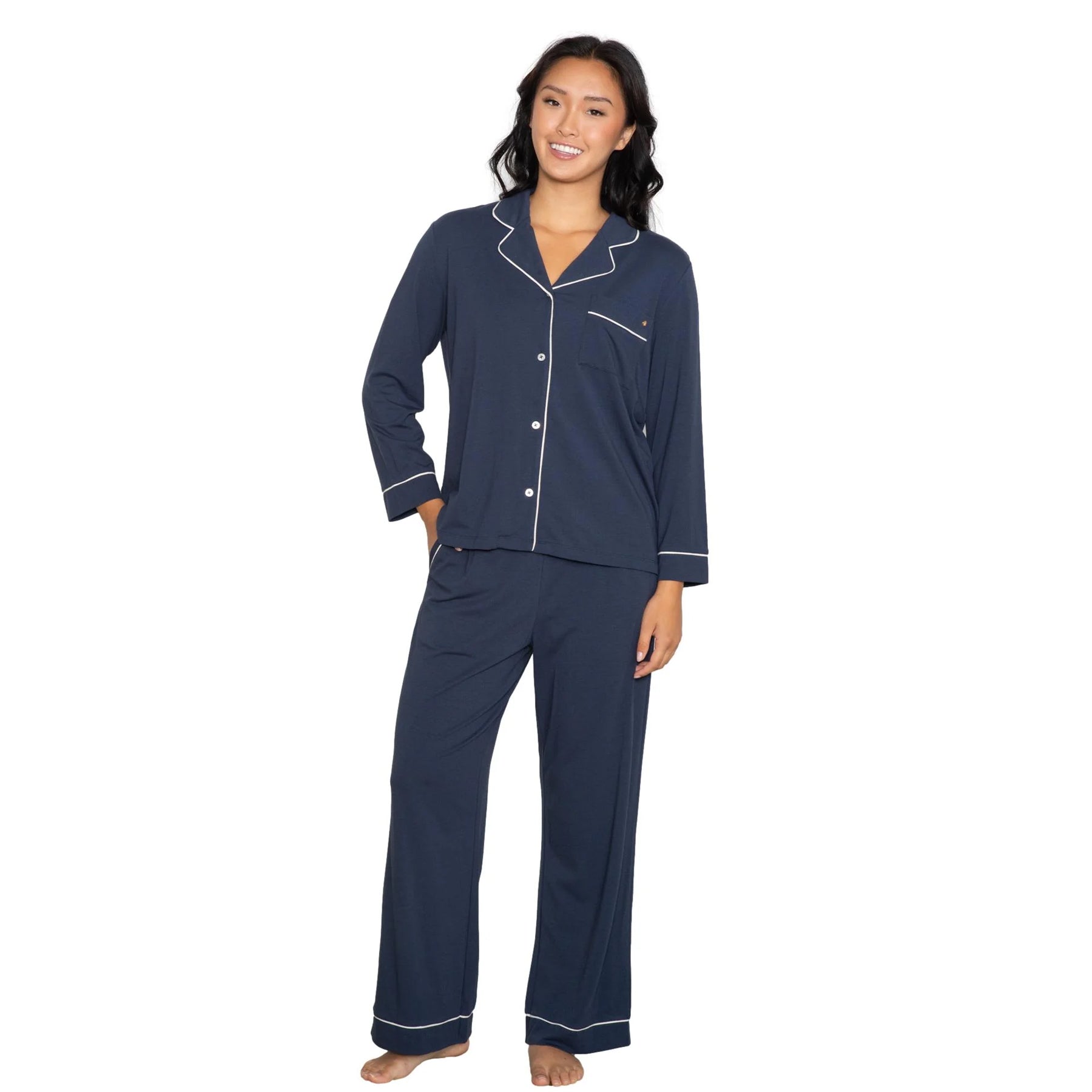 Navy long sleeve pyjama set with button-down top, chest pocket, and contrast piping, paired with relaxed straight-leg pants, front view on model