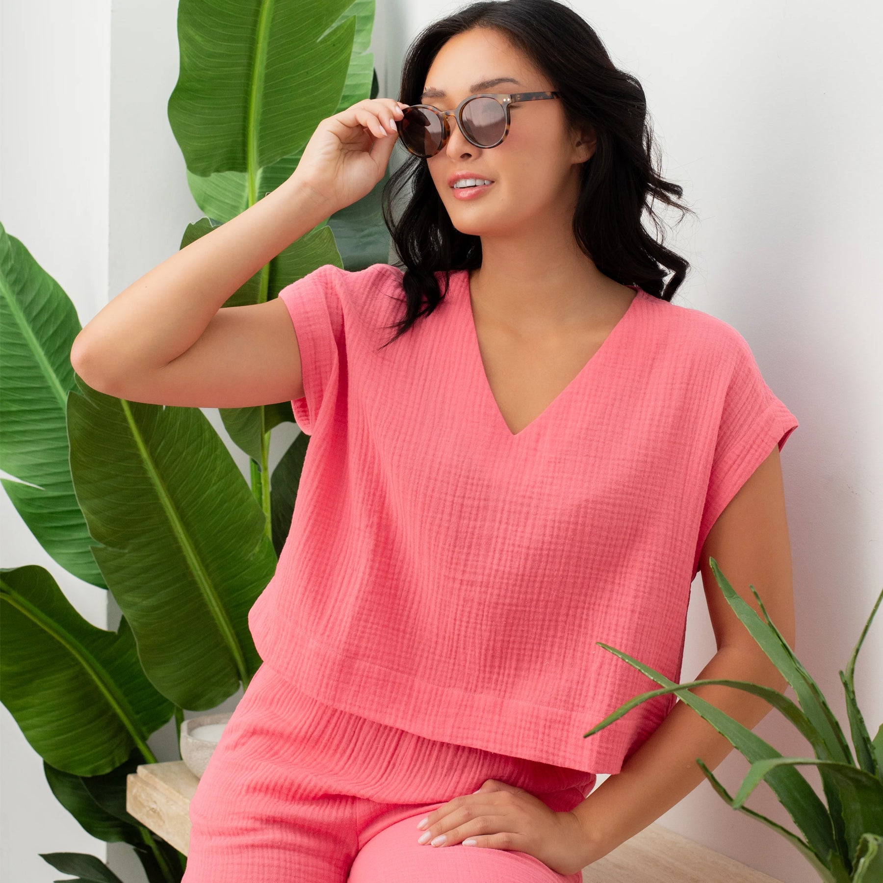Coral pink lounge set with V-neck cap sleeve top and cropped wide-leg pants, styled with sunglasses, lifestyle view