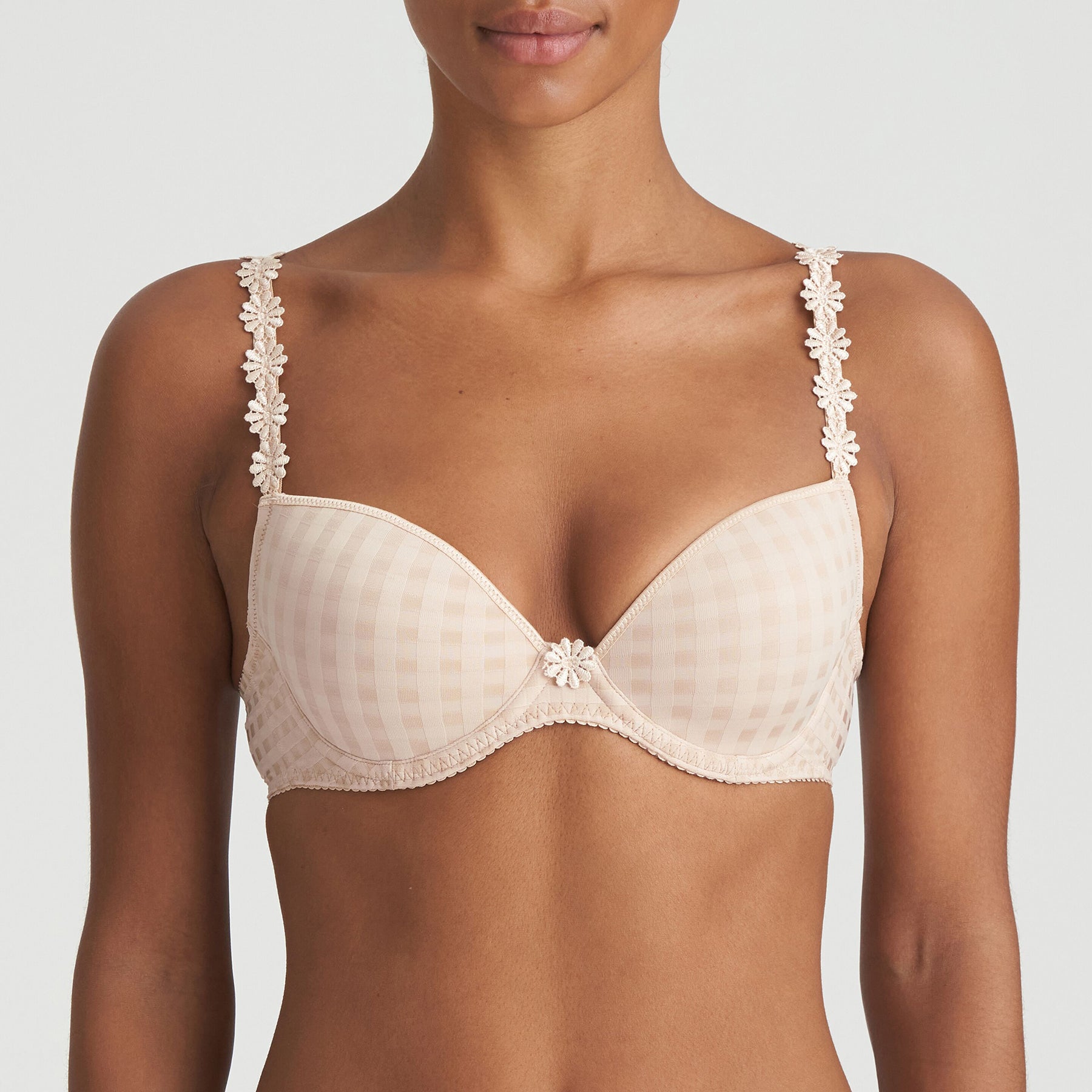 Padded plunge bra in nude cafe latte with checkerboard print and embroidered daisy straps. Front view on model. 