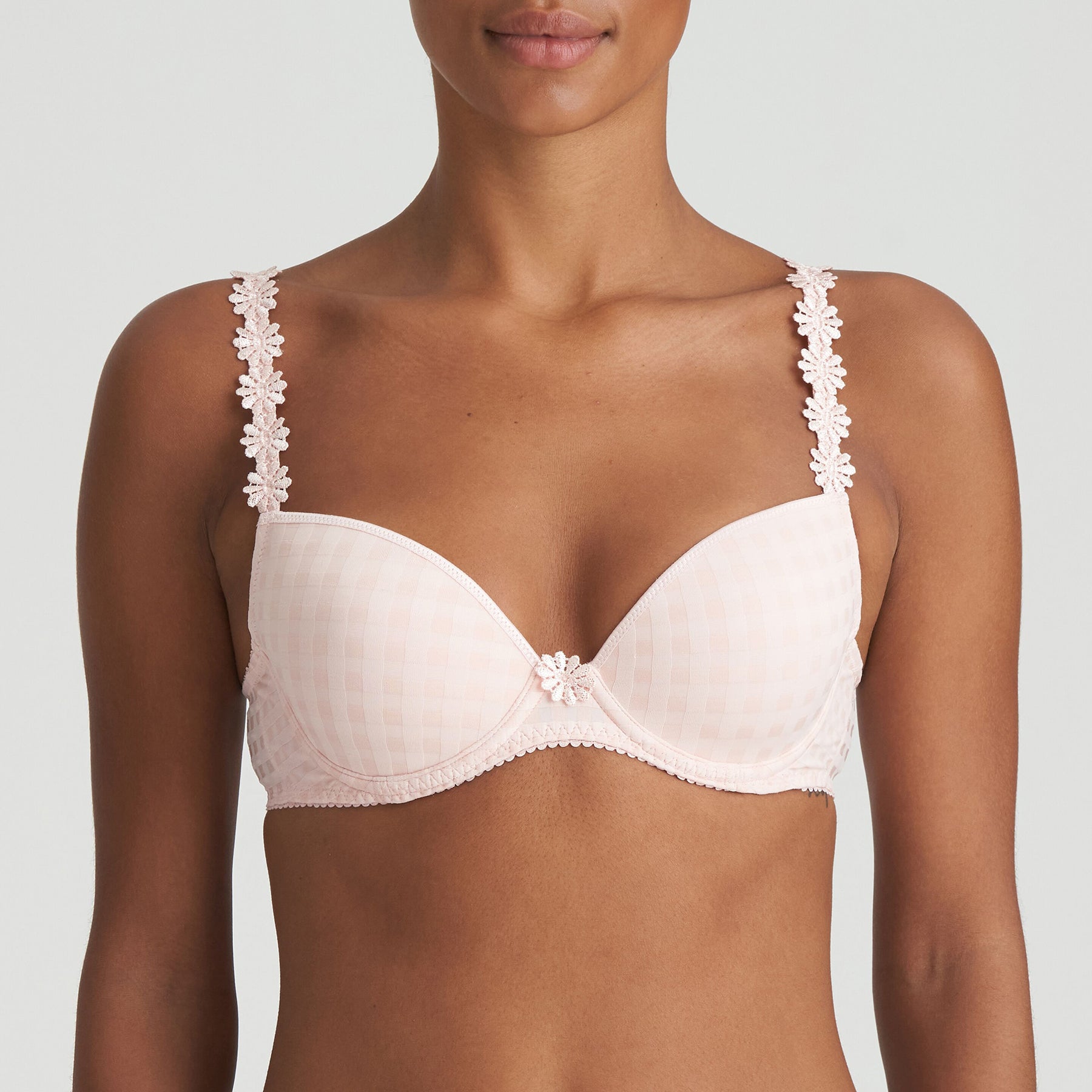 Padded plunge bra in pearly pink with checkerboard print and embroidered daisy straps. Front view on model. 