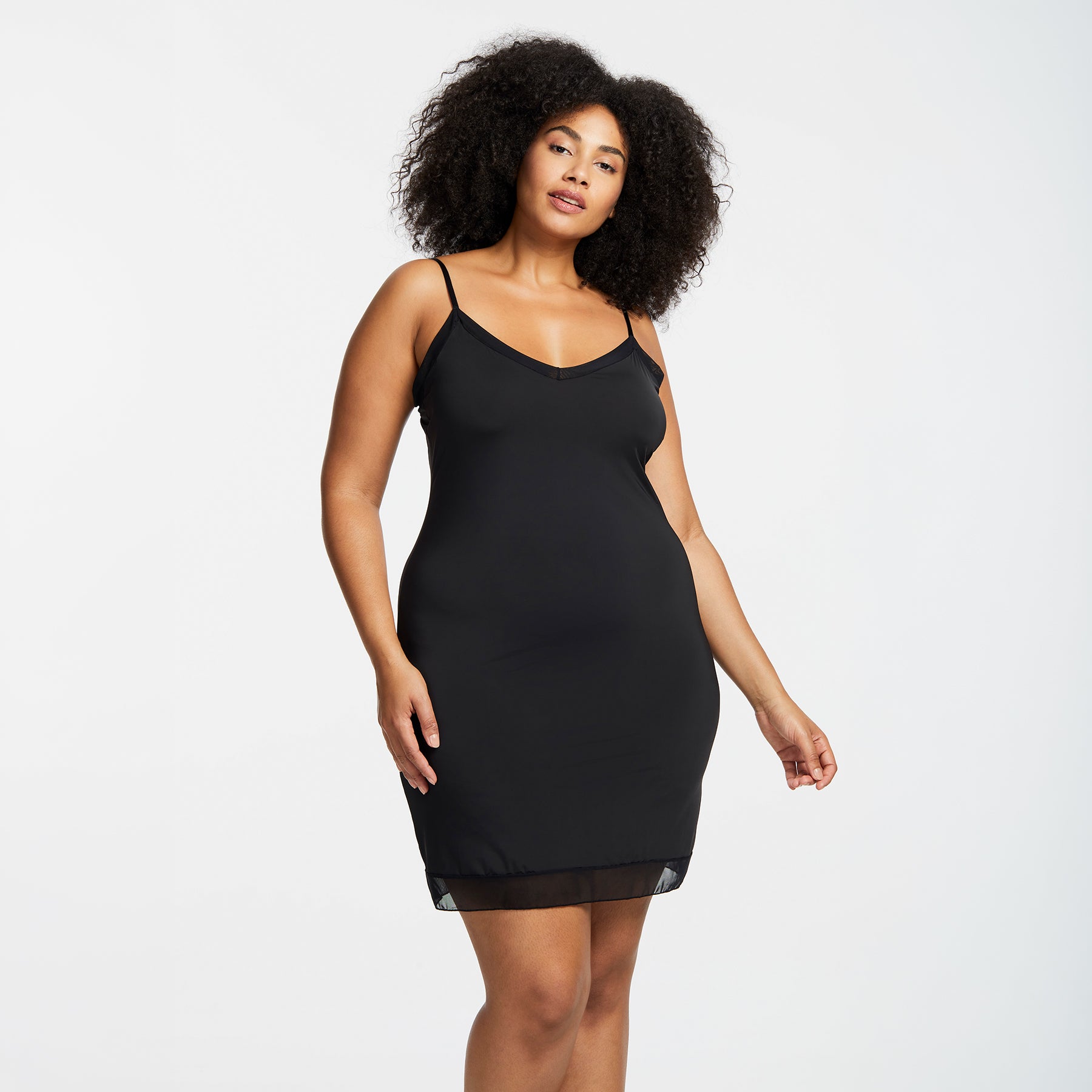 Montelle Intimates 9500 V-neck slip at knee in Black colour with sleek smoothing silhouette and sheer hem detail, front view on curvy model.