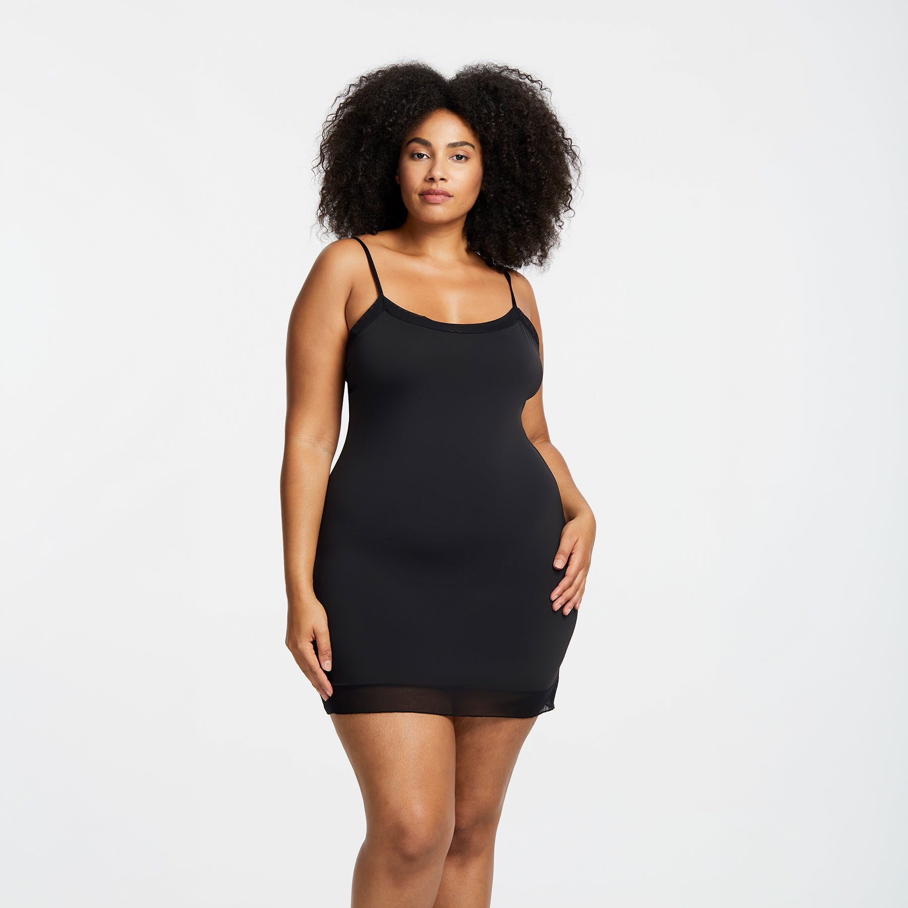 Montelle Intimates 9501 round neck slip above knee in Black colour with seamless smoothing design and sheer trim, front view on curvy model.