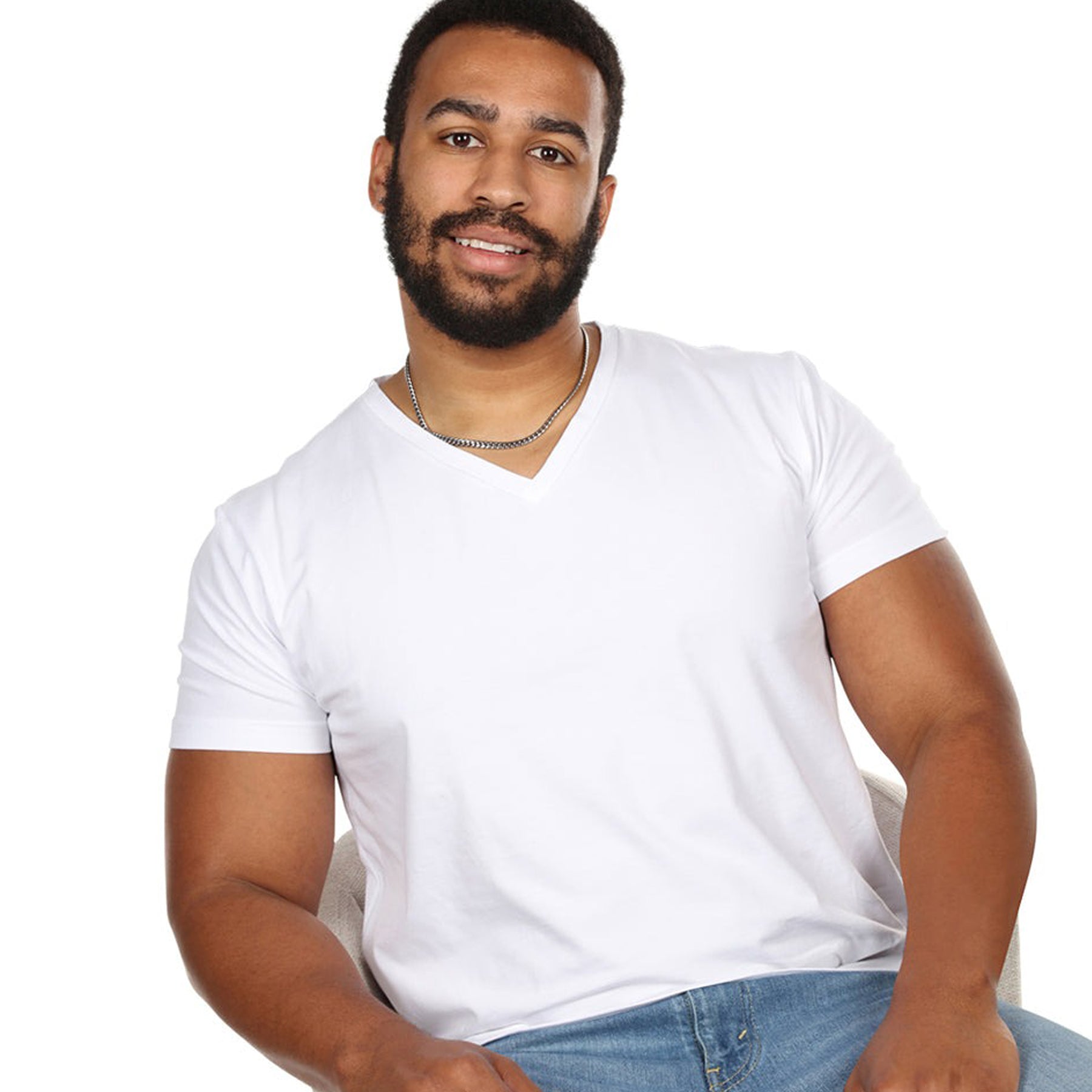 Man wearing MeMoi Men’s white cotton V-neck T-shirt, close-up seated view